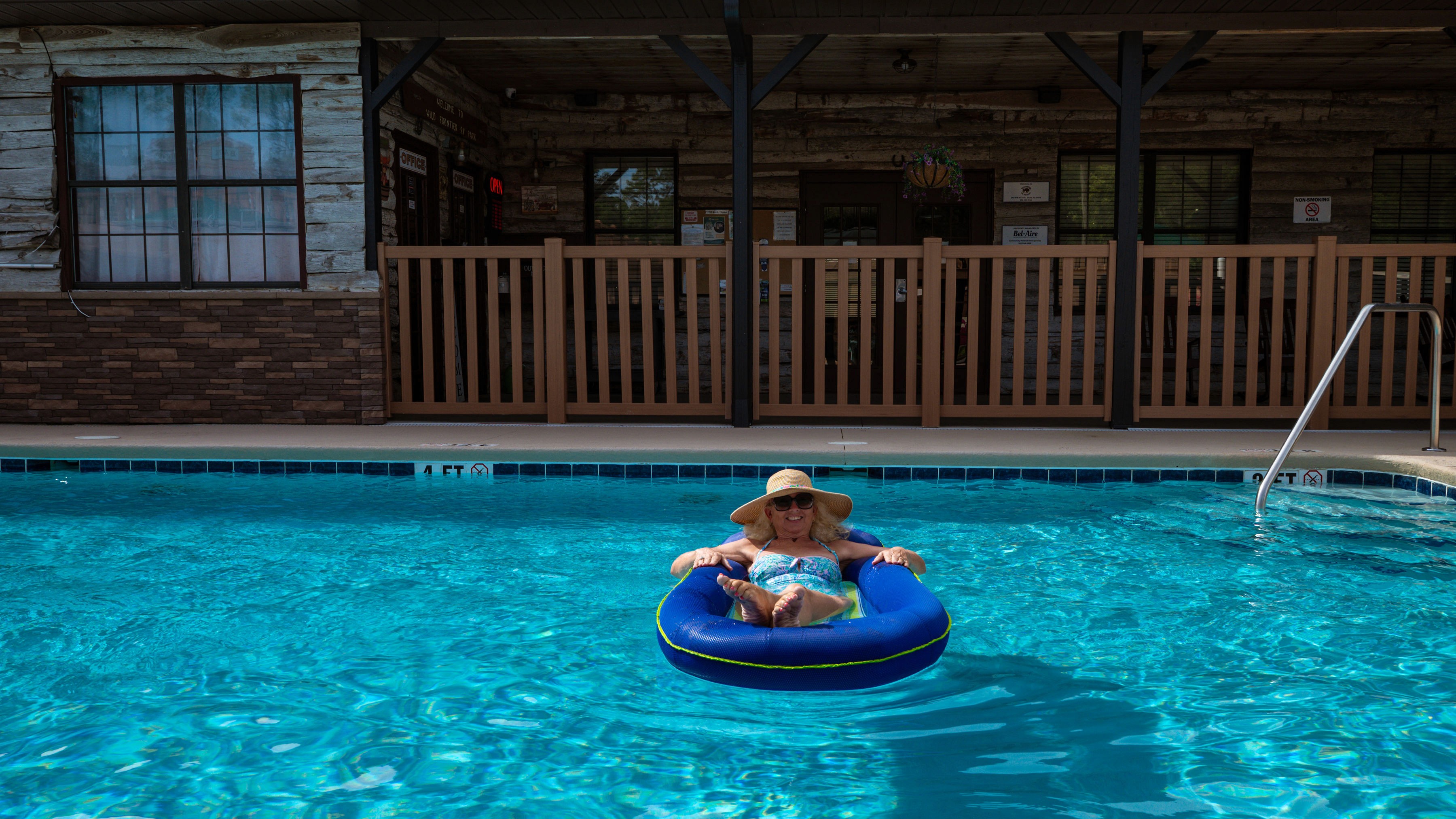 Woman floating on a blue tube in the resort pool
