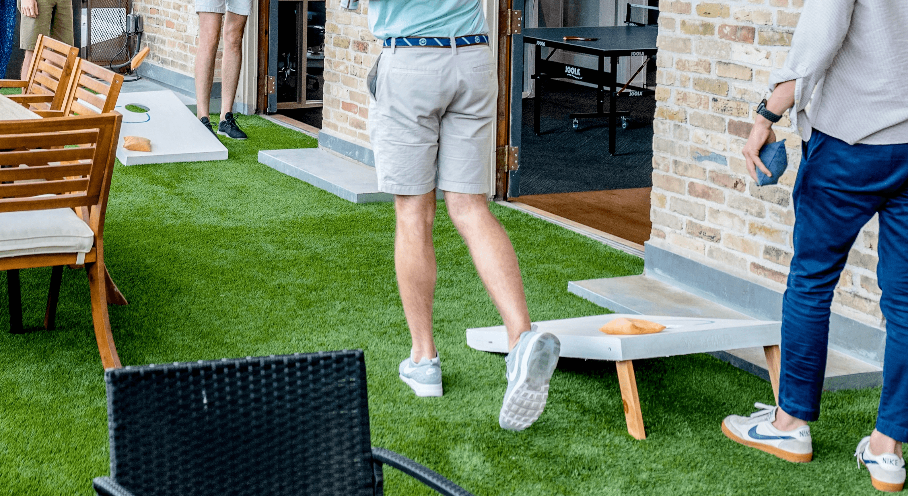 men playing cornhole boards