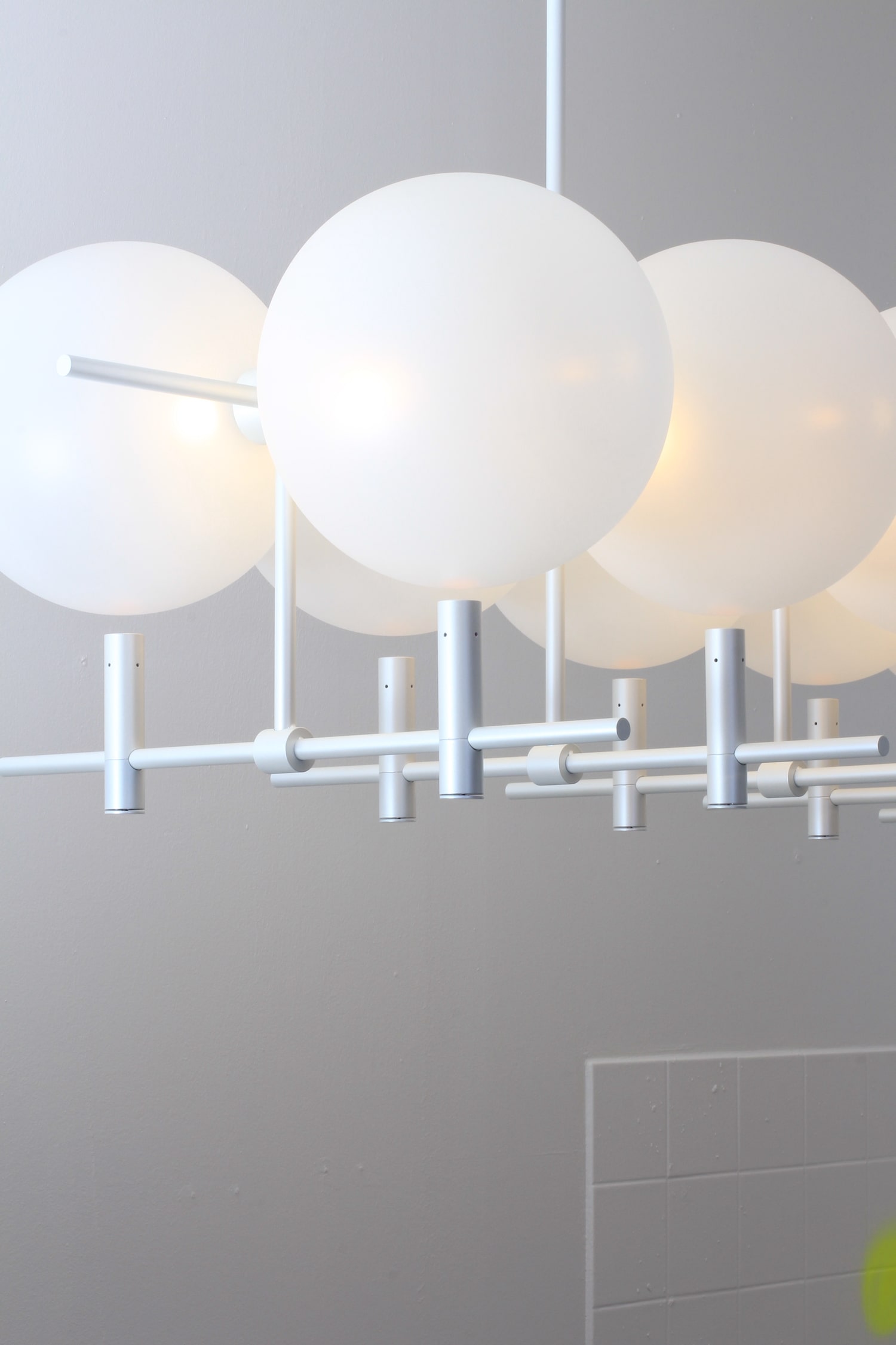Luna II horizontal luminaire installed in interior spanning space with glass spheres and metal structure by Jiri Krejcirik