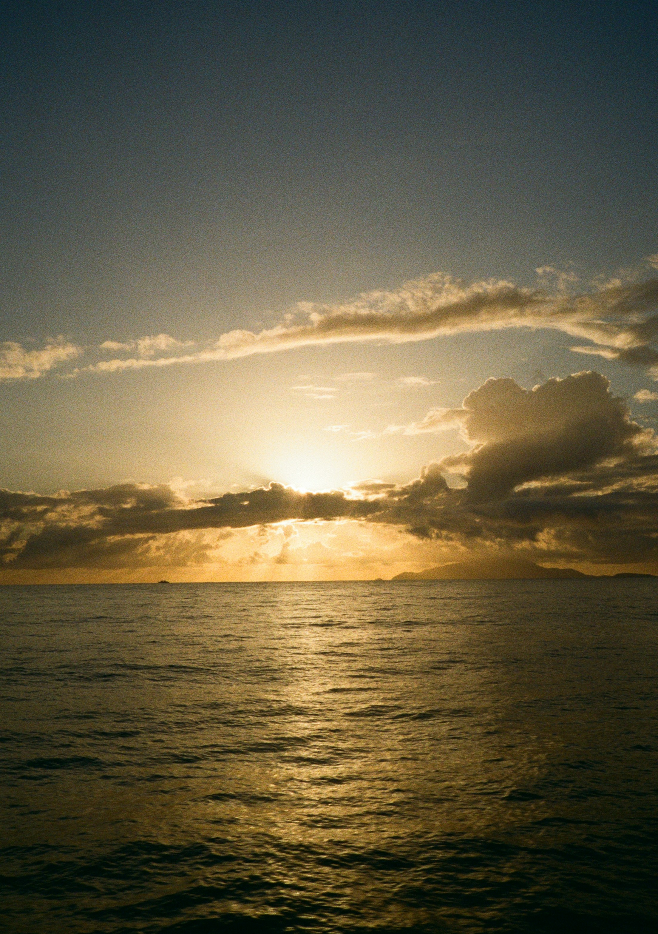 Golden sunset over the calm ocean with clouds