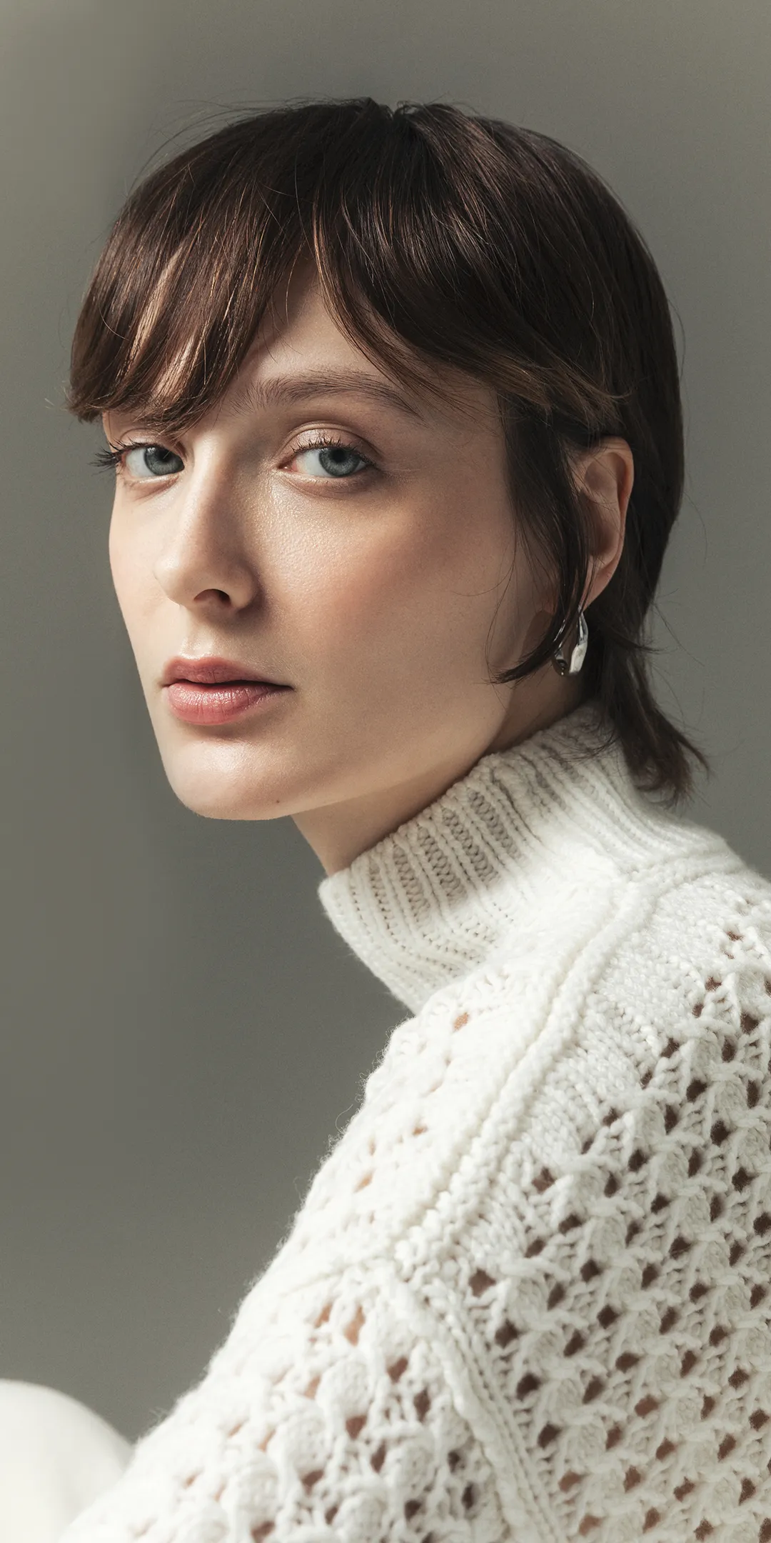 Woman wearing white open-knit cashmere sweater by Aida Barni – Italian craftsmanship and timeless design.