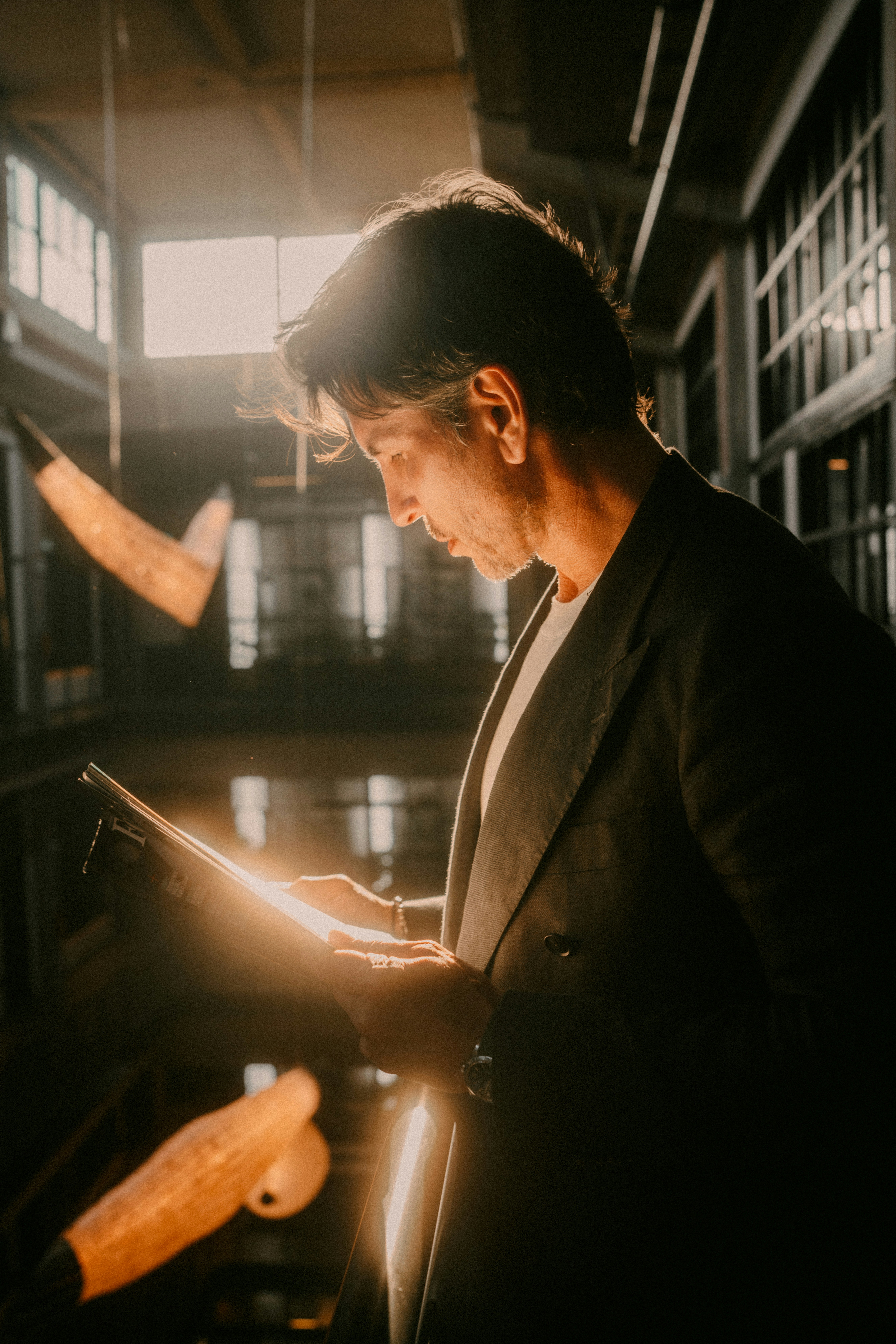A man in a suit looking at a book