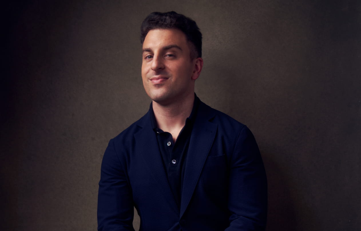 A glass planthouse from the outside in an expansive empty desert at dawn.