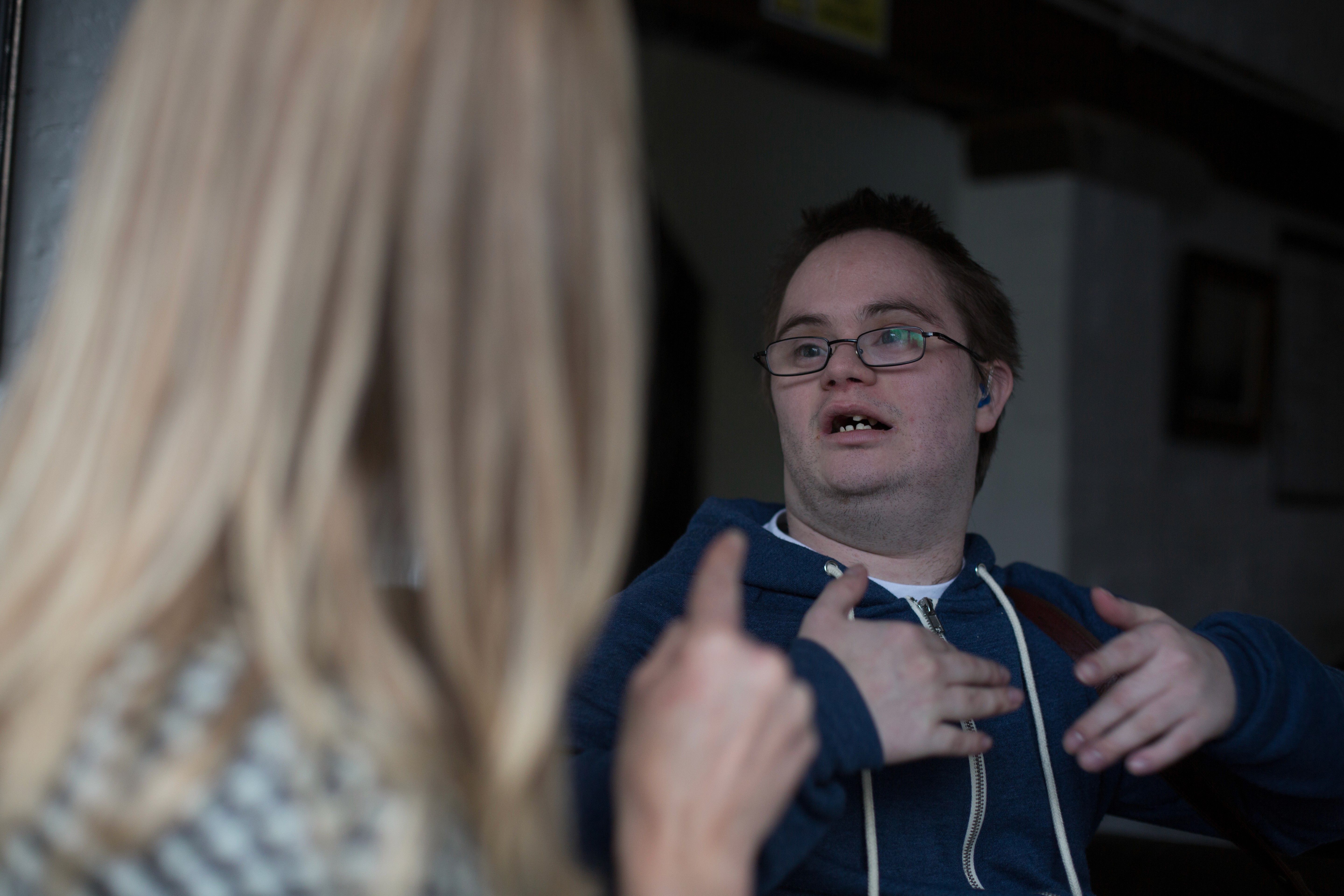 Man with Downsyndrome signing to support worker