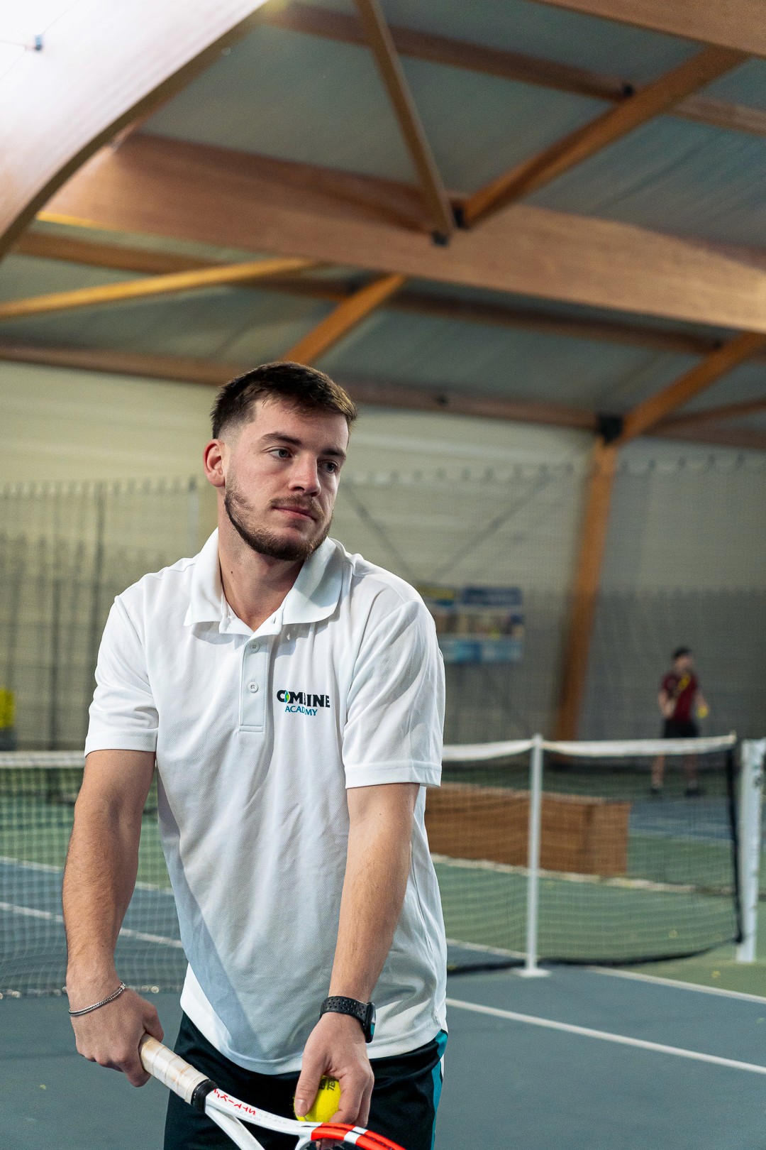 Entraîneur Aurélien Arlot préparant une balle sur sa raquette au Combine Elite Tennis Camp.