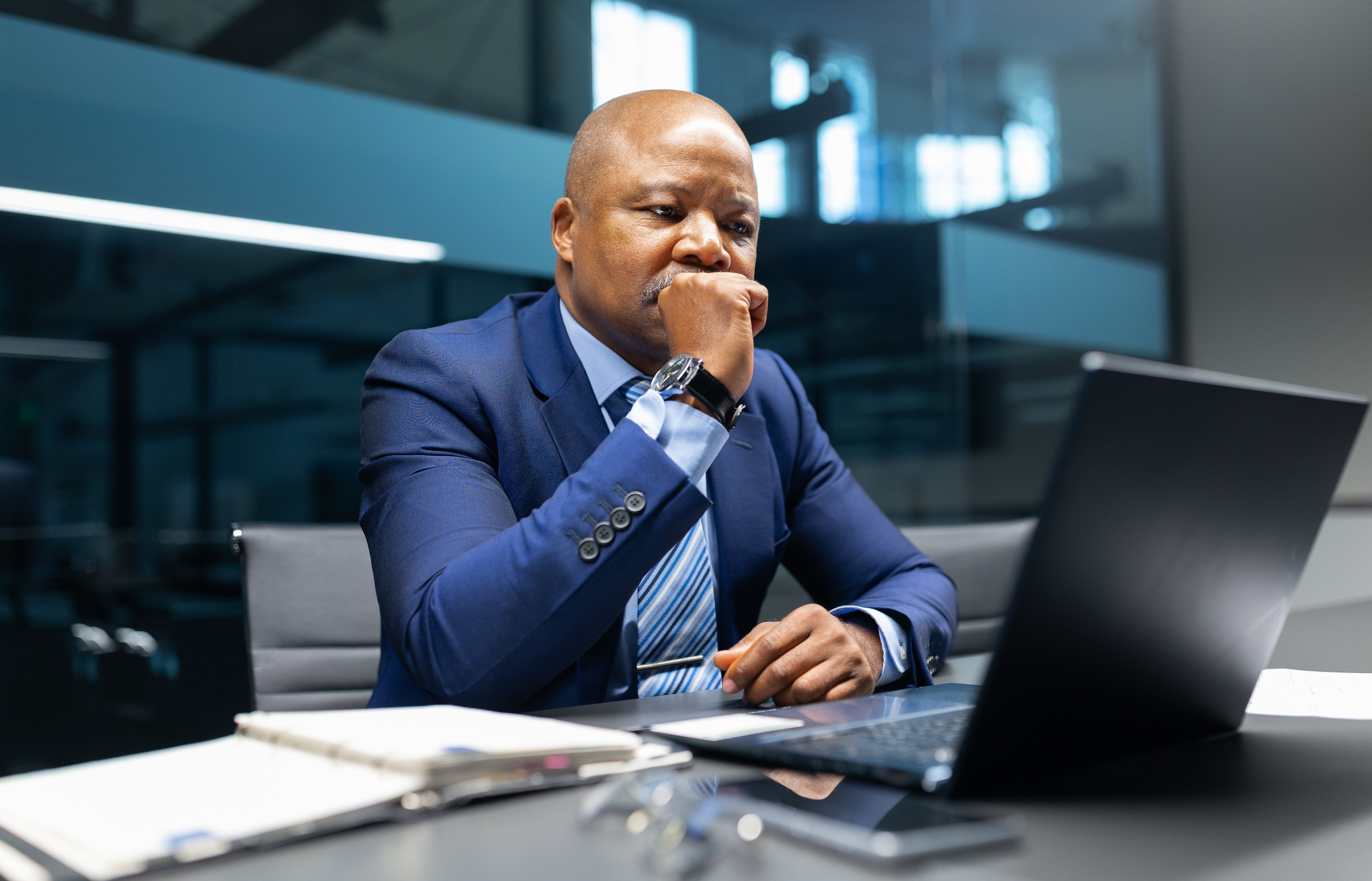 Professional reviewing data on a laptop, evaluating performance and effectiveness of a management system