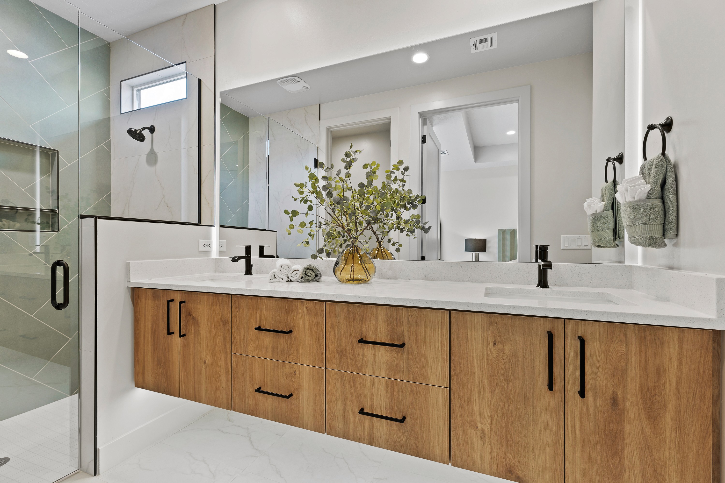 Master bathroom in the BYSO House in Hurricane, Utah with a spacious vanity, walk-in shower, and light finishes.