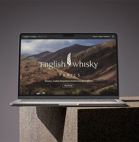 English Whisky Trails Project graphic of a laptop feturing the new visual identity and logo