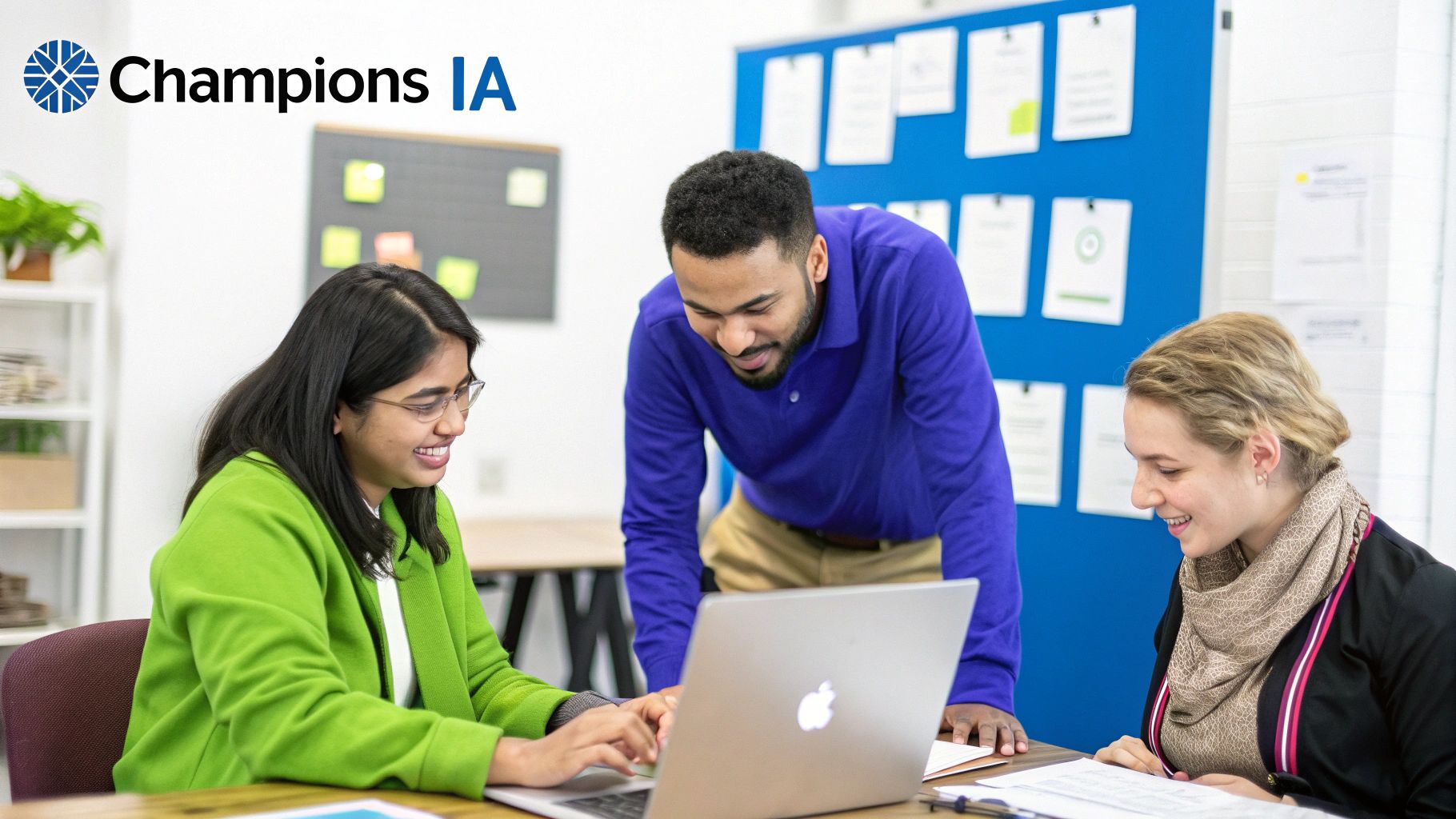 Trois collègues souriants collaborent sur un ordinateur portable dans un bureau moderne.