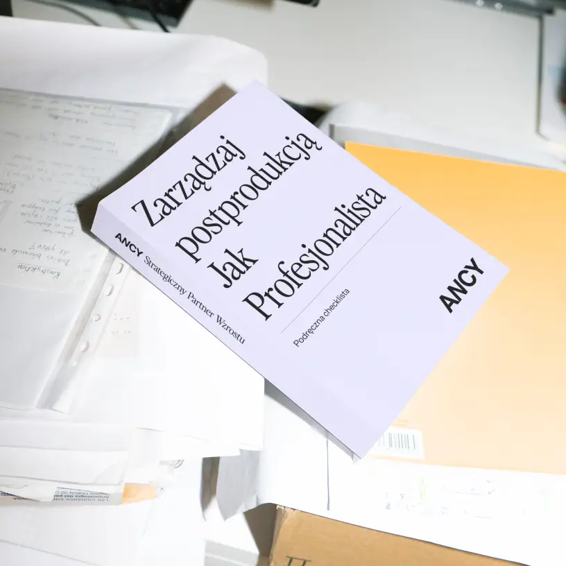 Okładka checklisty „Zarządzaj postprodukcją jak profesjonalista” leżąca na biurku z dokumentami