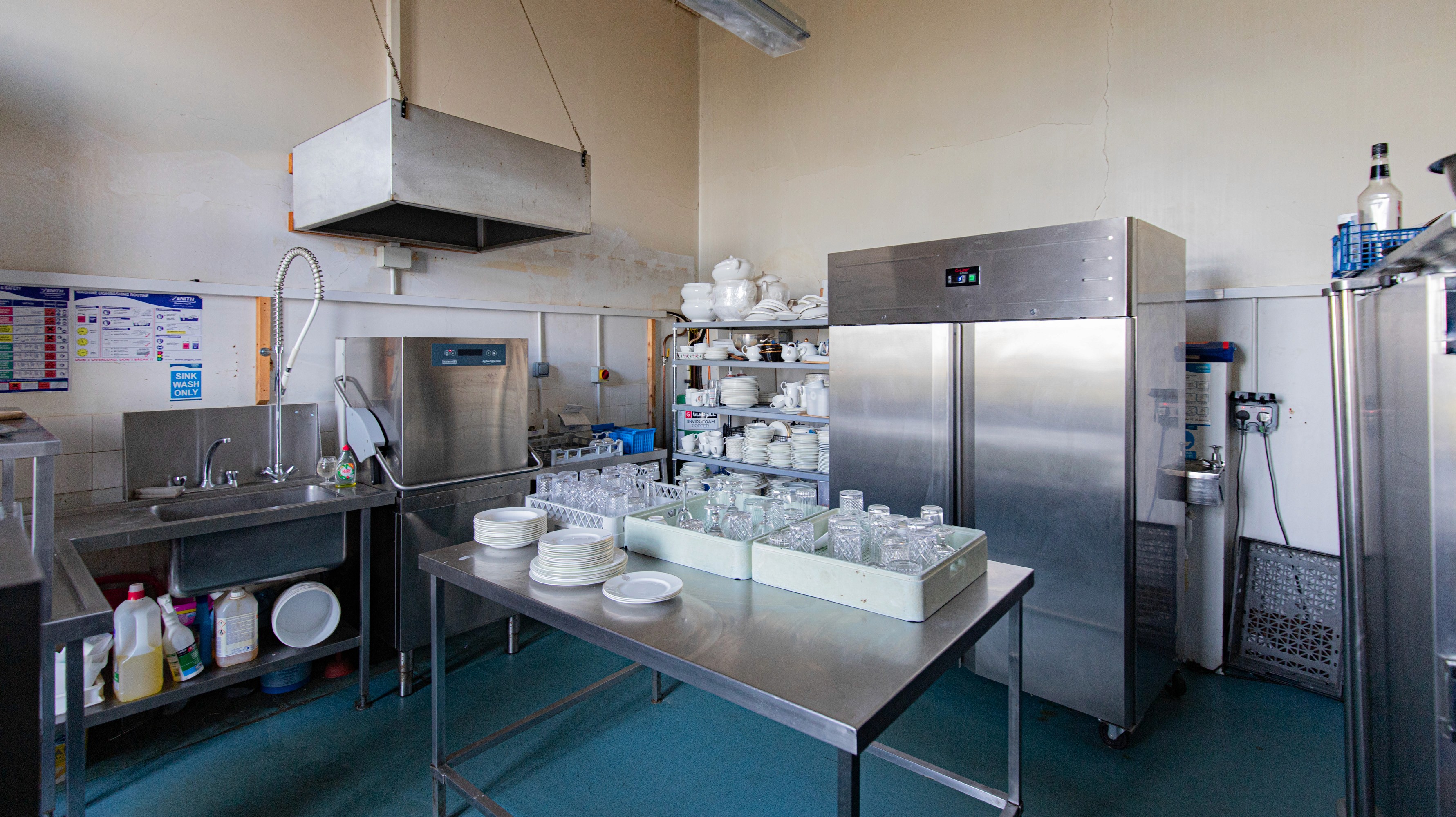 Two classic volkswagen beetles, one green, one cream.