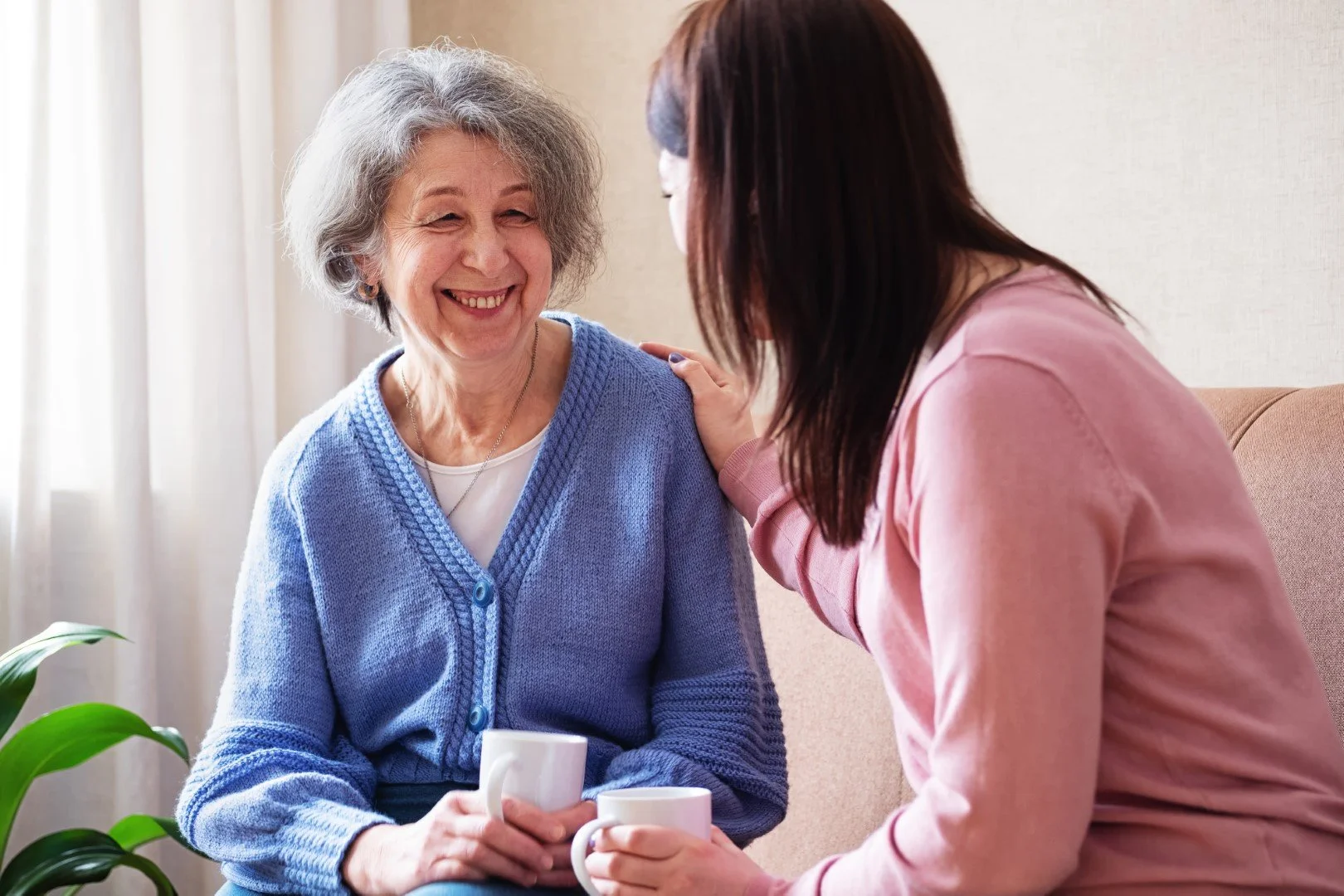 Three women talking and smiling in a room