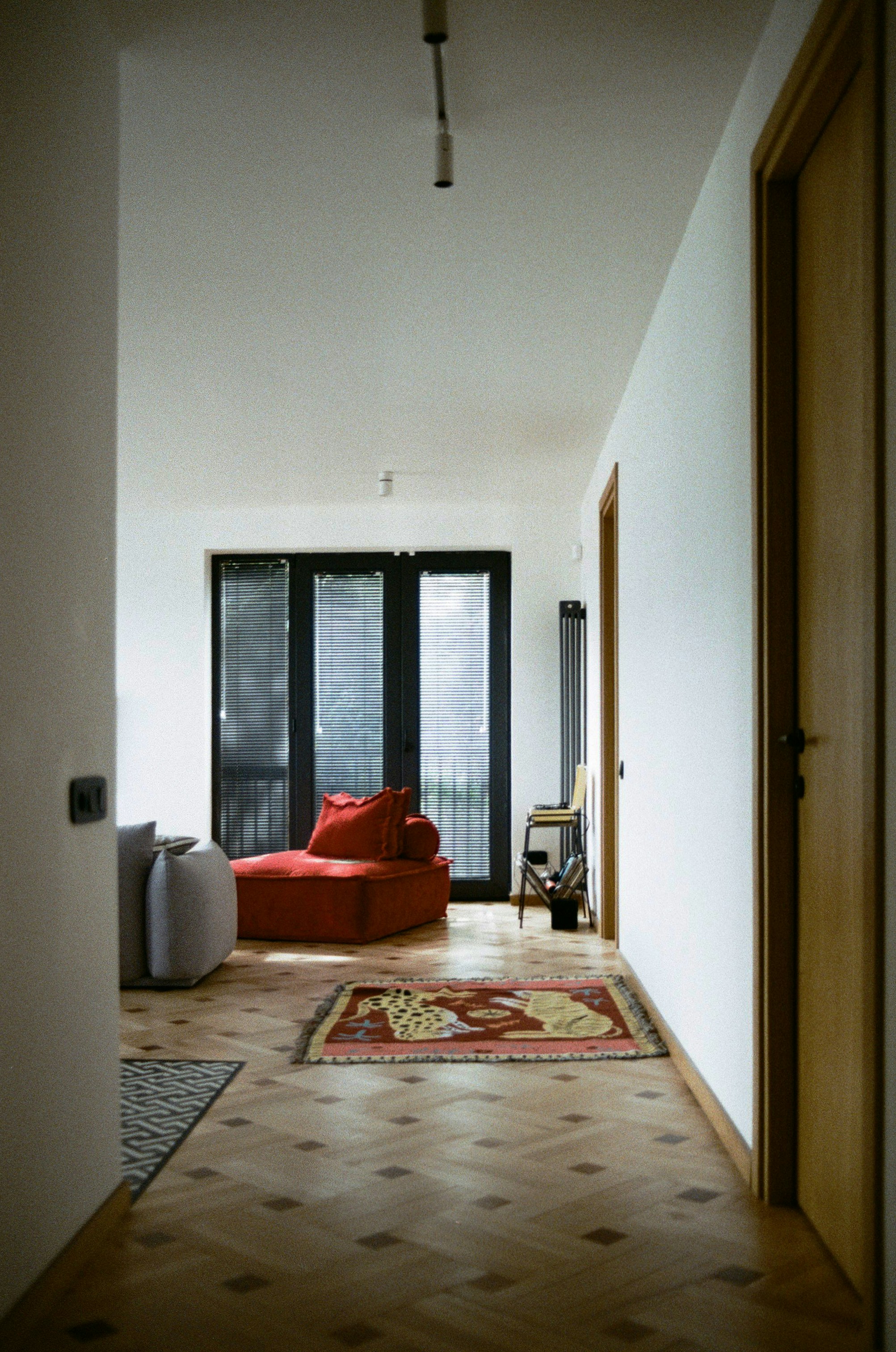 a living room with a red couch and a rug
