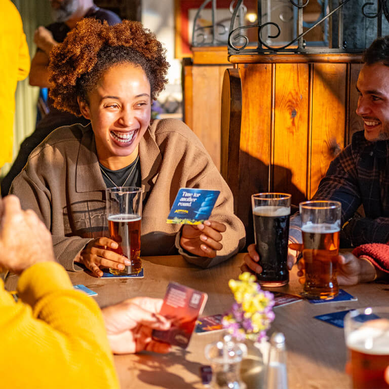 Group of people in the pub drinking Adnams