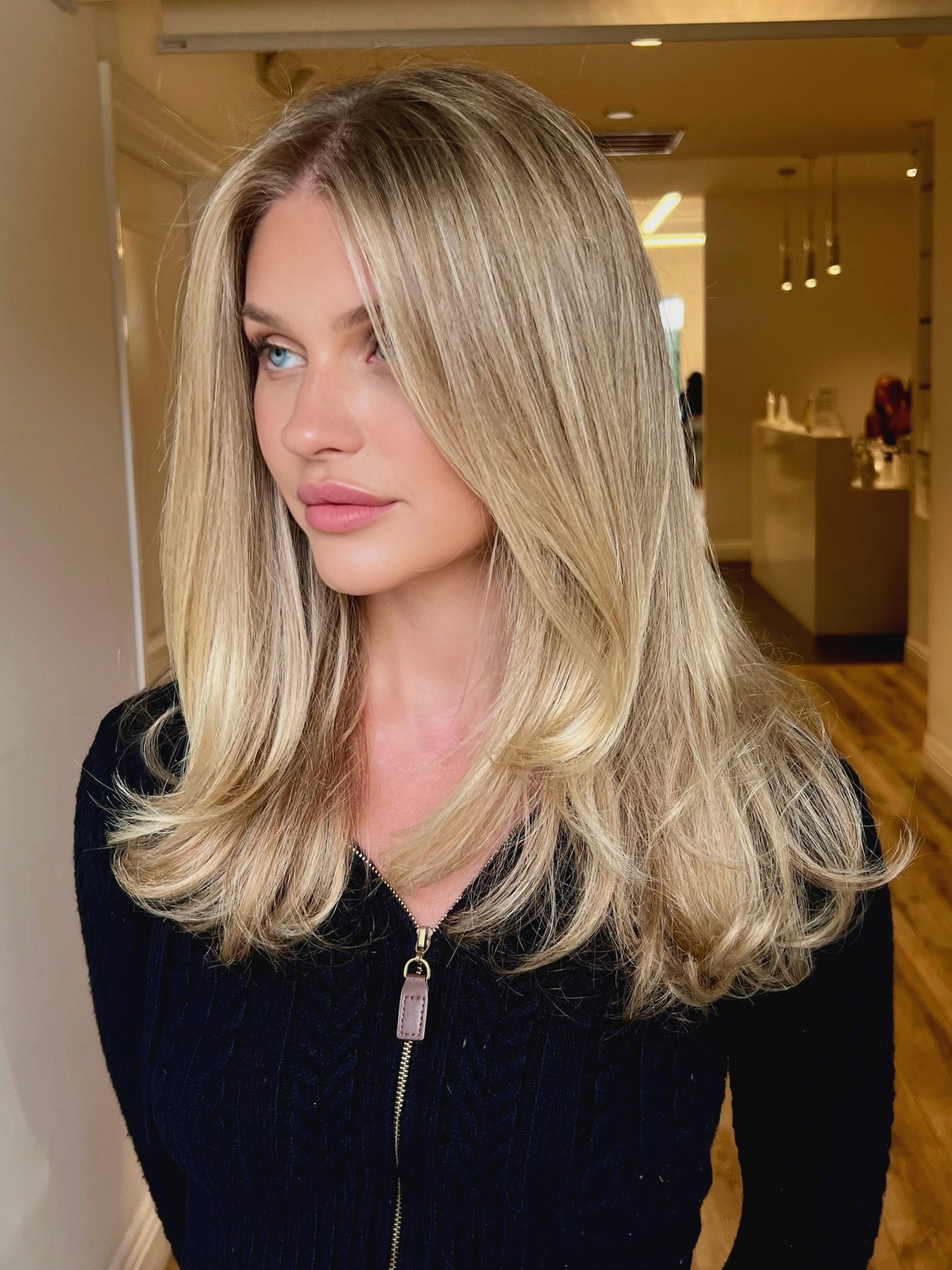 Sunkissed blonde with 90s blowout at Bomane Salon – voluminous, soft layers for a natural blonde look.