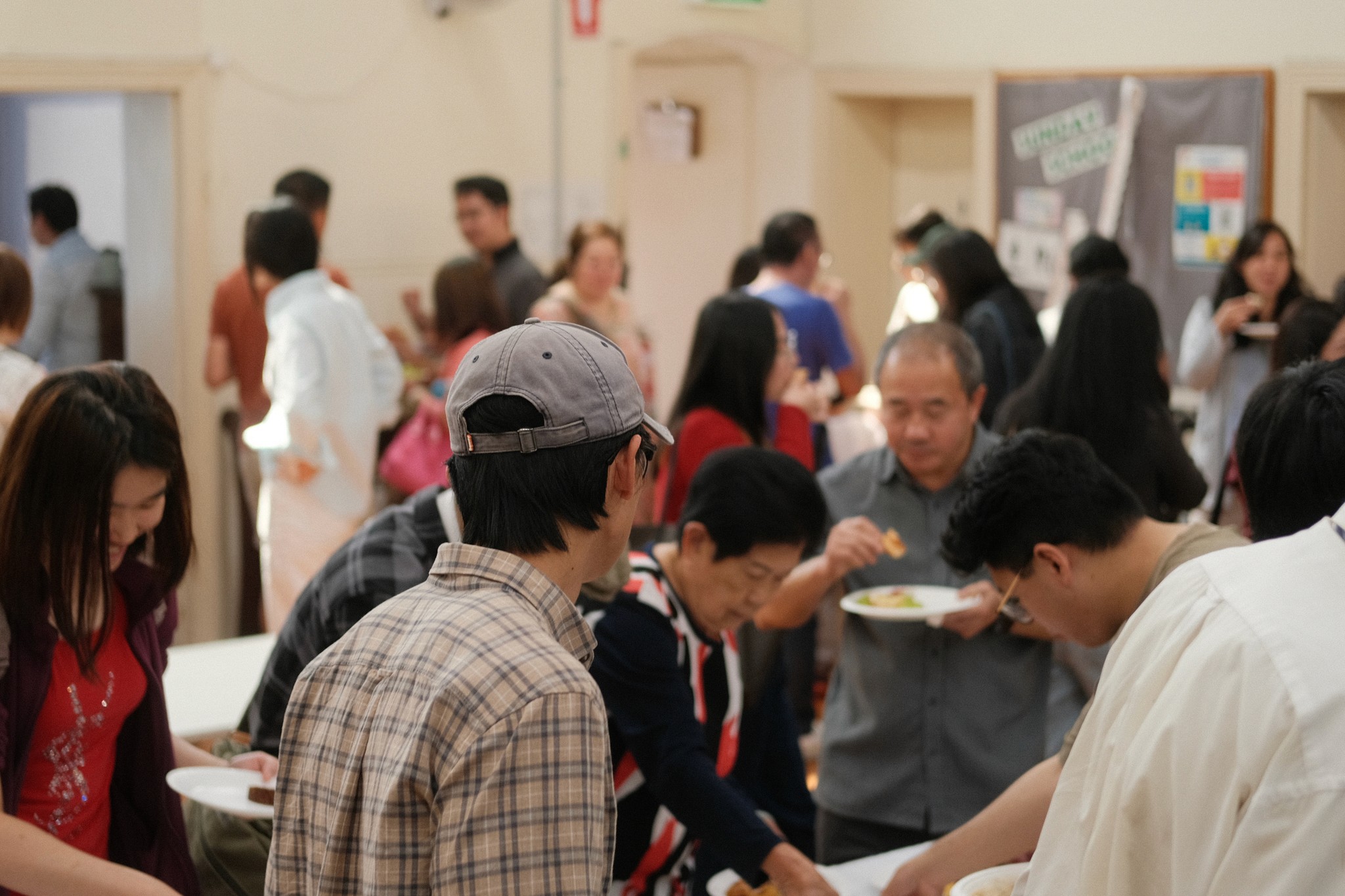 A restaurant interior featuring marble countertops, brown leather chairs, wood-paneled walls, and round pendant lights hanging above a bar set with wine glasses.