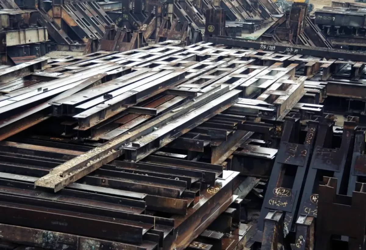 Stacks of structural steel beams in a storage yard