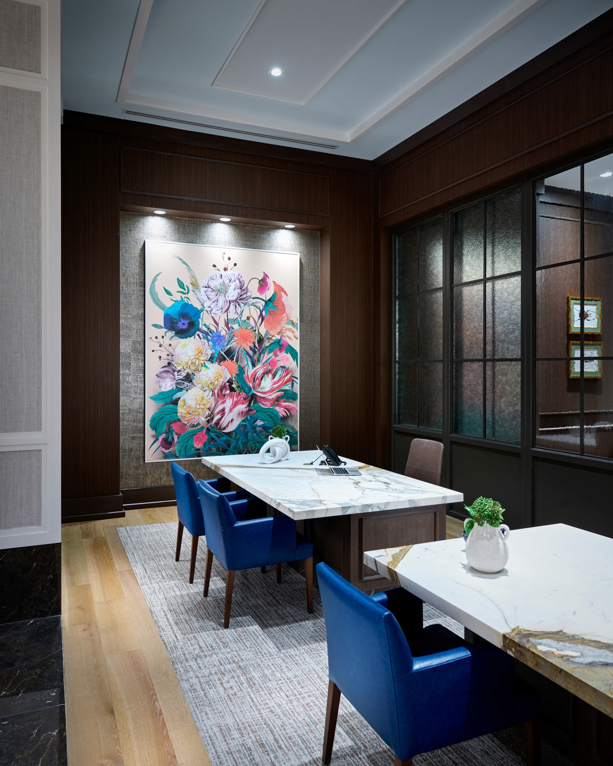 Office with floral artwork and marble table.