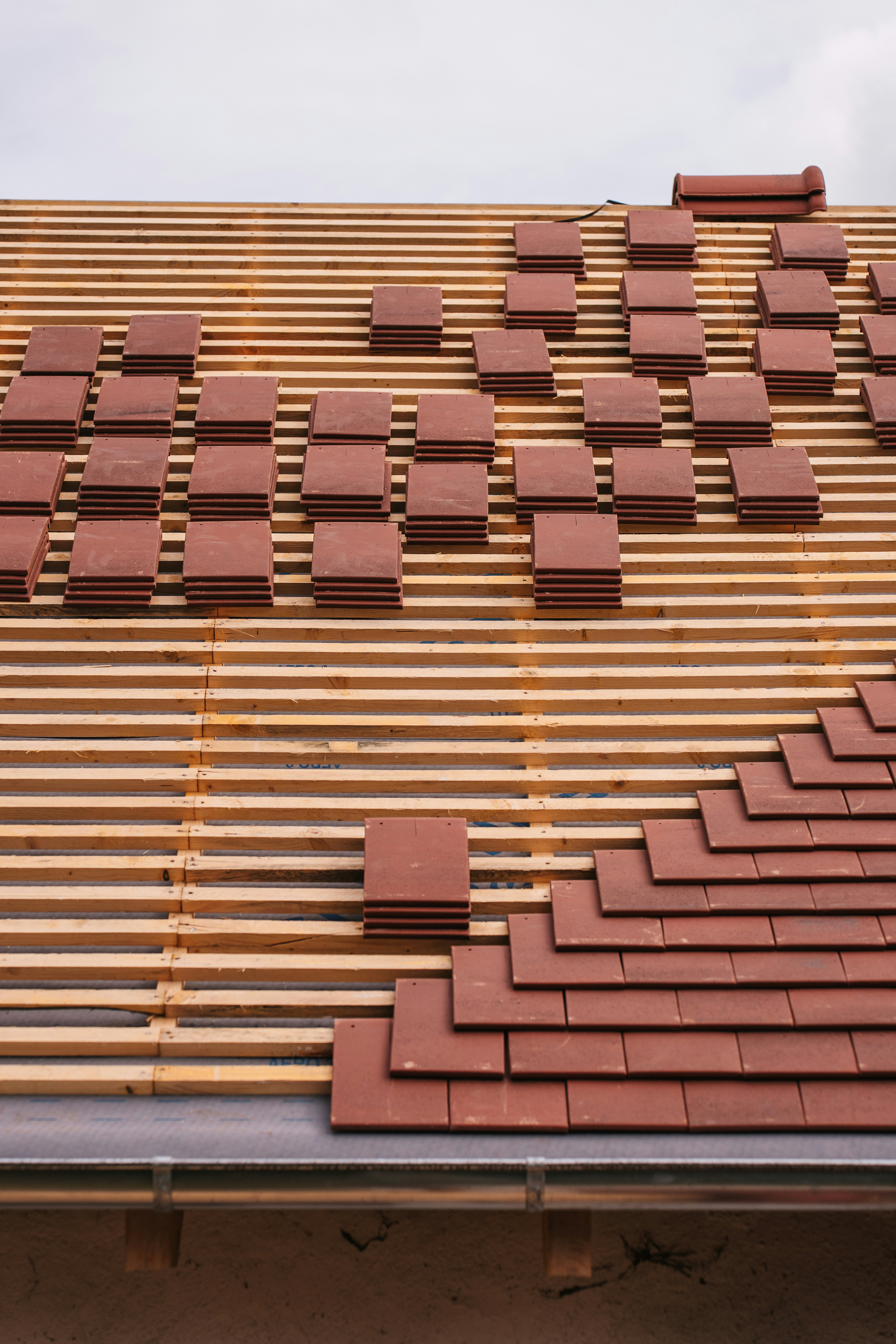 Roof tiles being laid on a wooden frame.