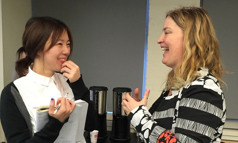 A photo of two women talking to each other.