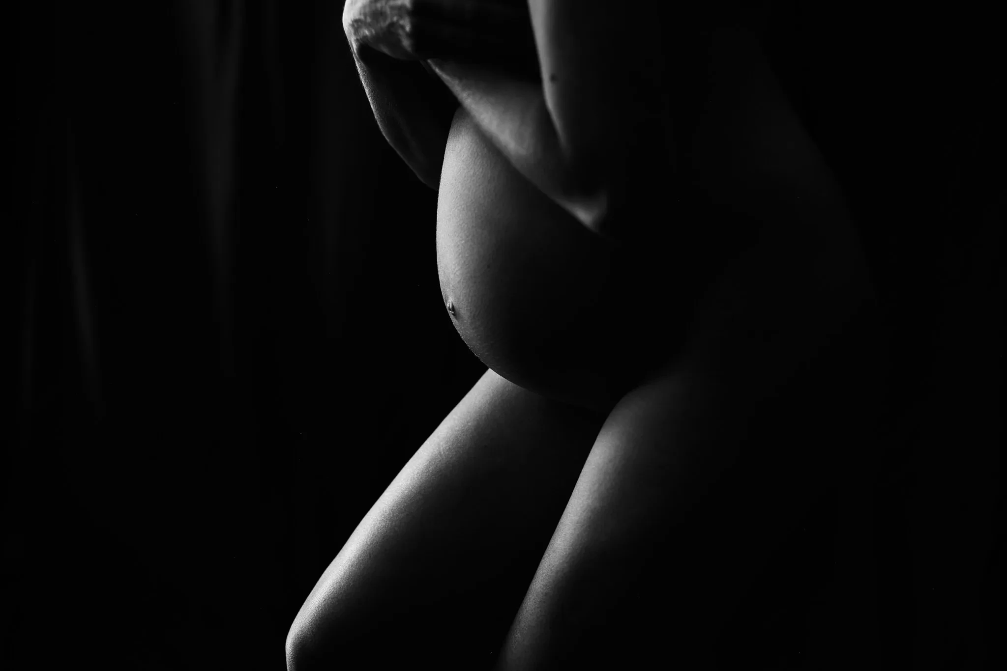 pregnant belly in low side light — portrait photography by Tom Kubik