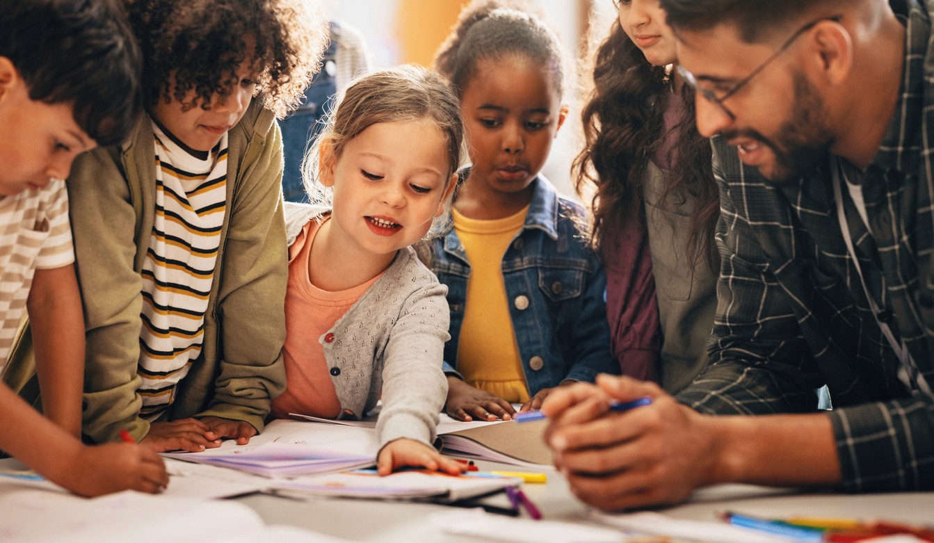 students learning with teacher in a classroom