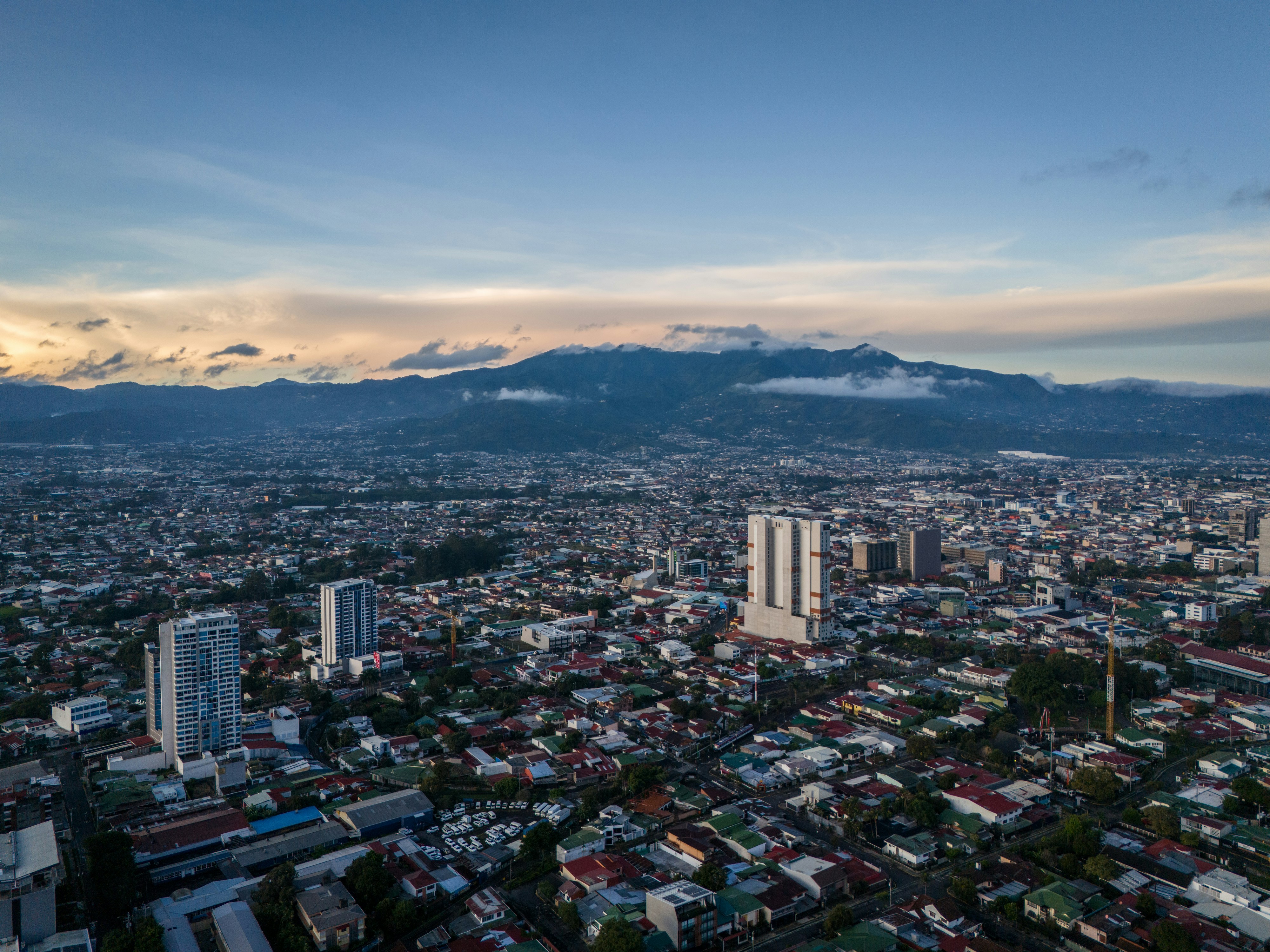 an aerial view of a city with mountains in the background