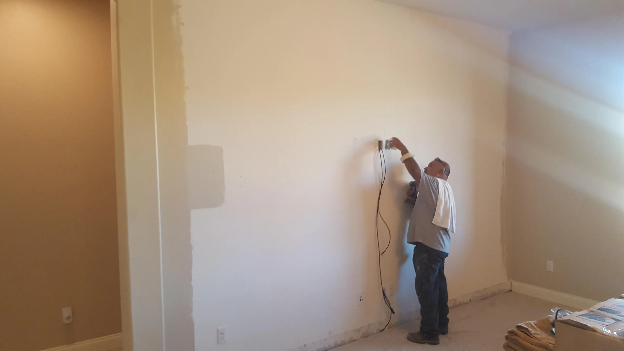 Painter applying a fresh coat to an interior wall in a Tucson home