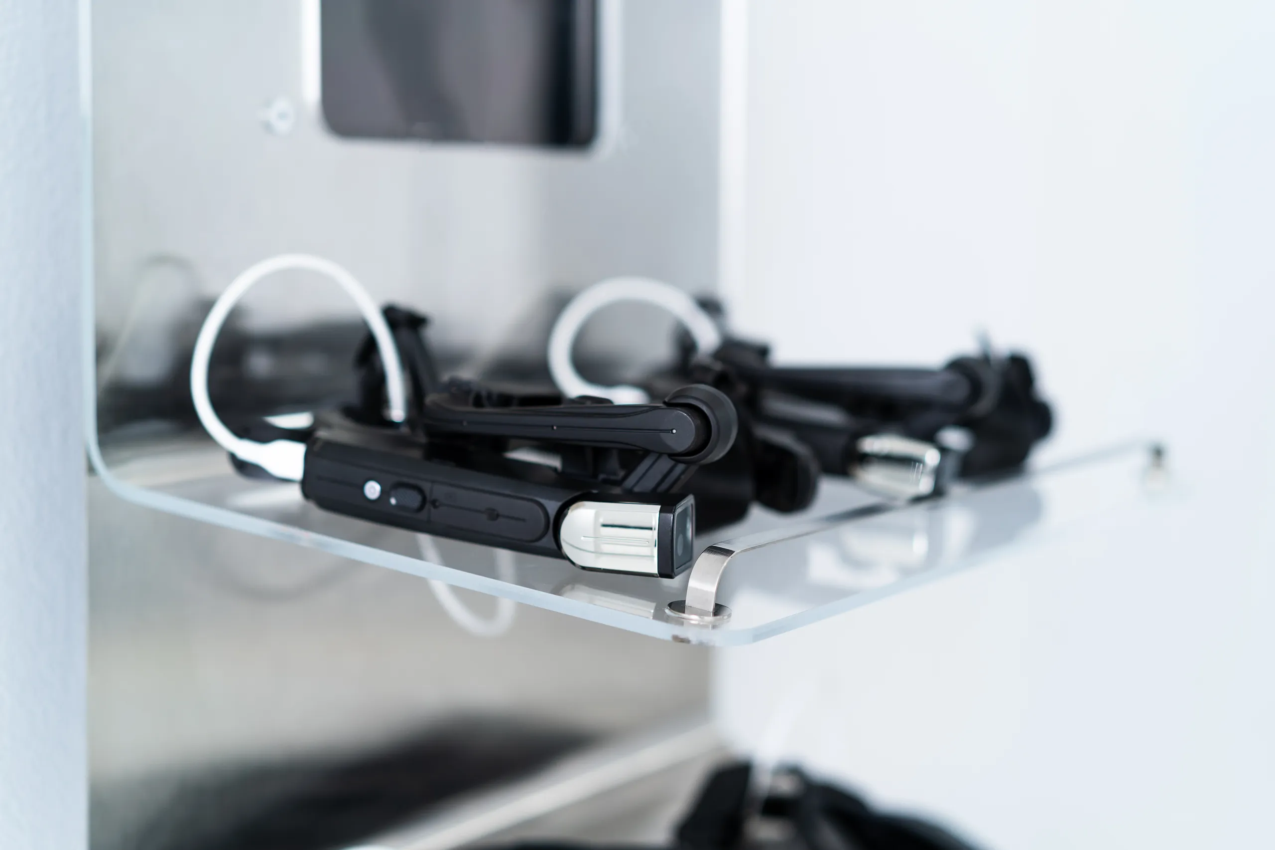 Close-up of multiple Apprentice wearable headsets stored on a clear docking shelf