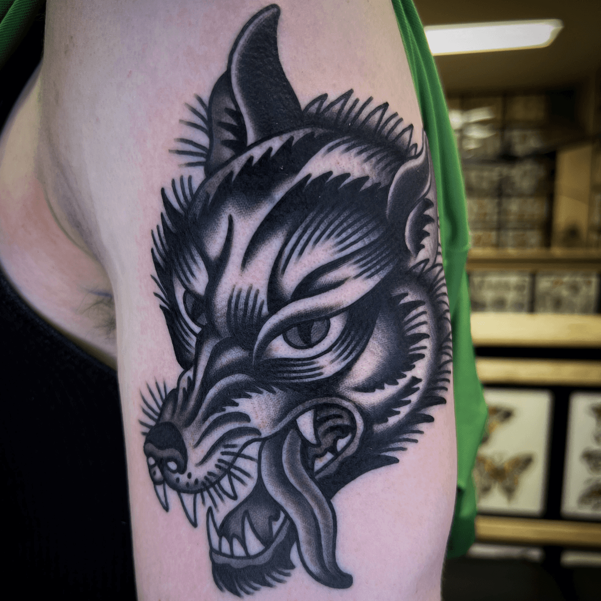 black and gray tattoo of a wolf head