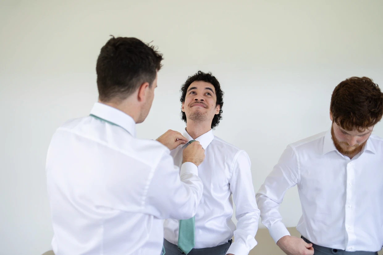 Groomsman fixing their ties