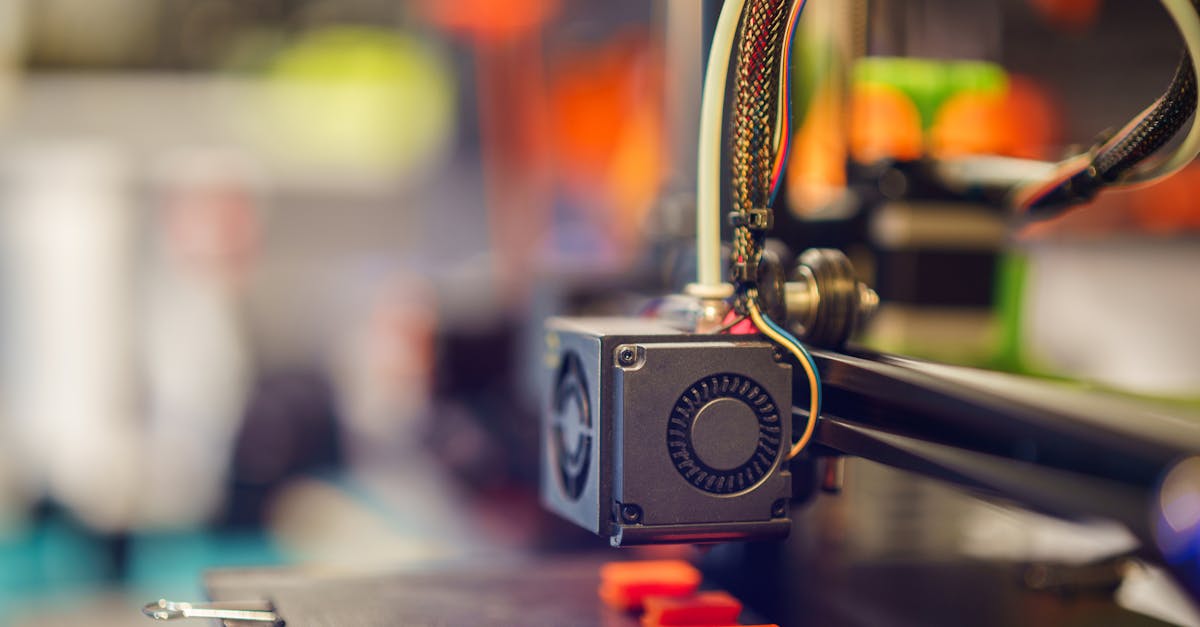 Detailed close-up of a 3D printer extruding red plastic during operation.