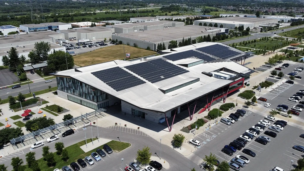 the Aaniin Community Centre in Markham with solar panels on the roof, surrounded by a parking lot