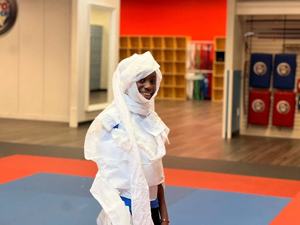 Kid wrapped in toilet paper as a mummy.