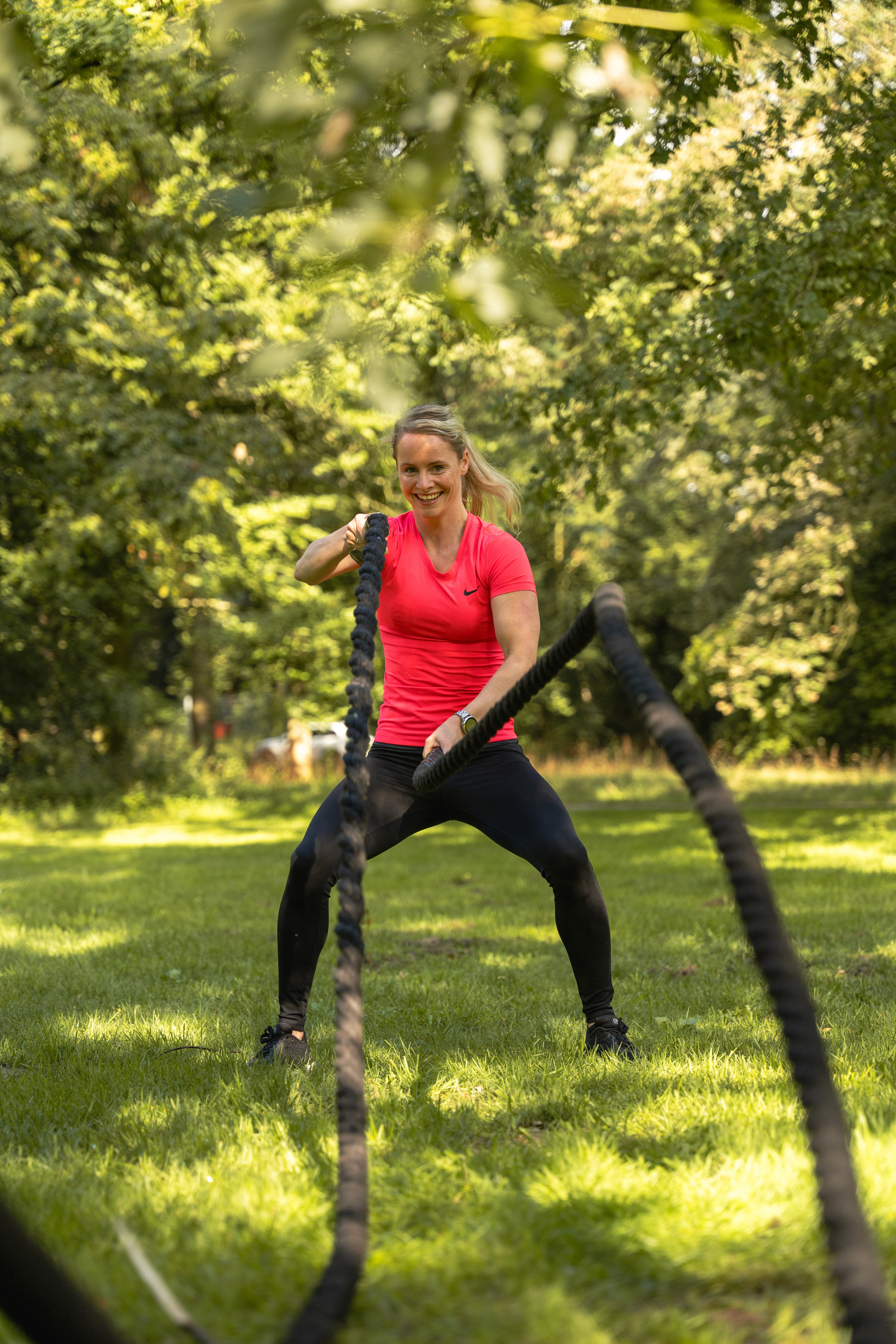 A smiling young man with crossed arms, wearing a plaid shirt and white t-shirt, poses against a dark background.
