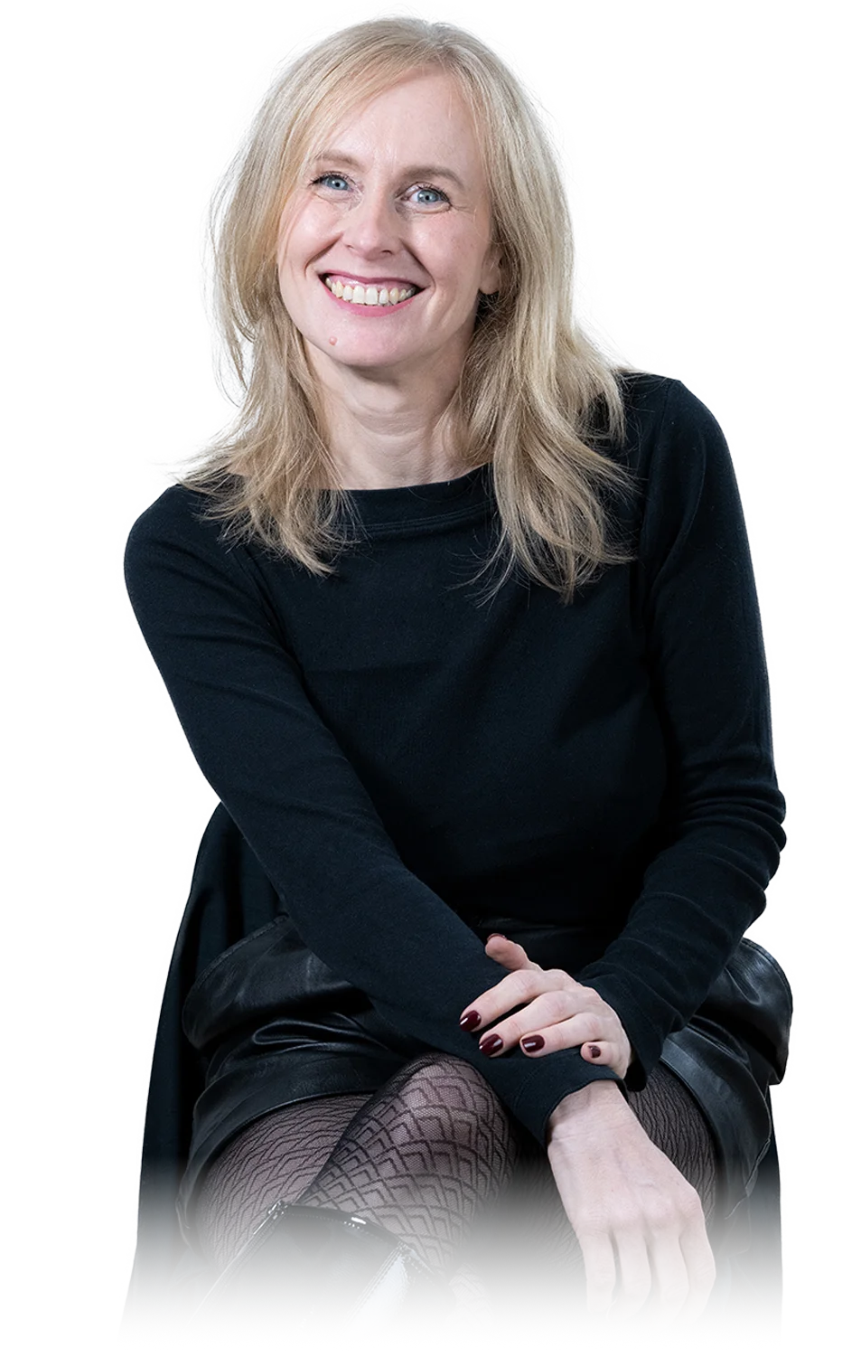 A woman sits cross-legged with eyes closed, wearing a white blouse and a long purple skirt, looking serene.