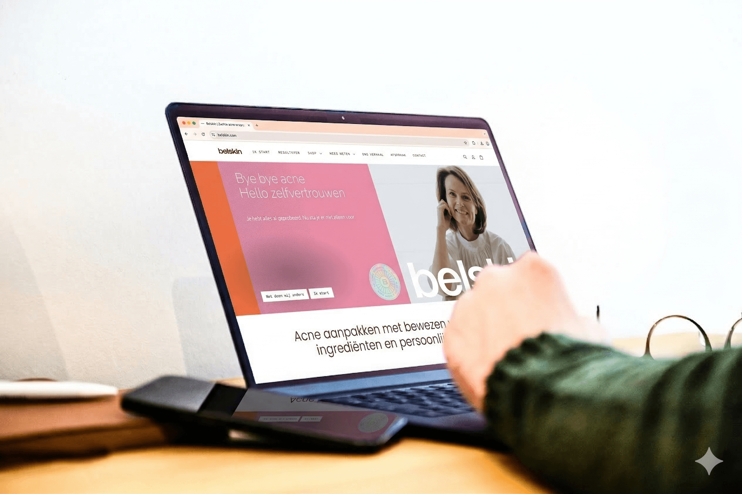 zijaanzicht van een laptop met de arm van Johan en de homepagina van Belskin op het scherm