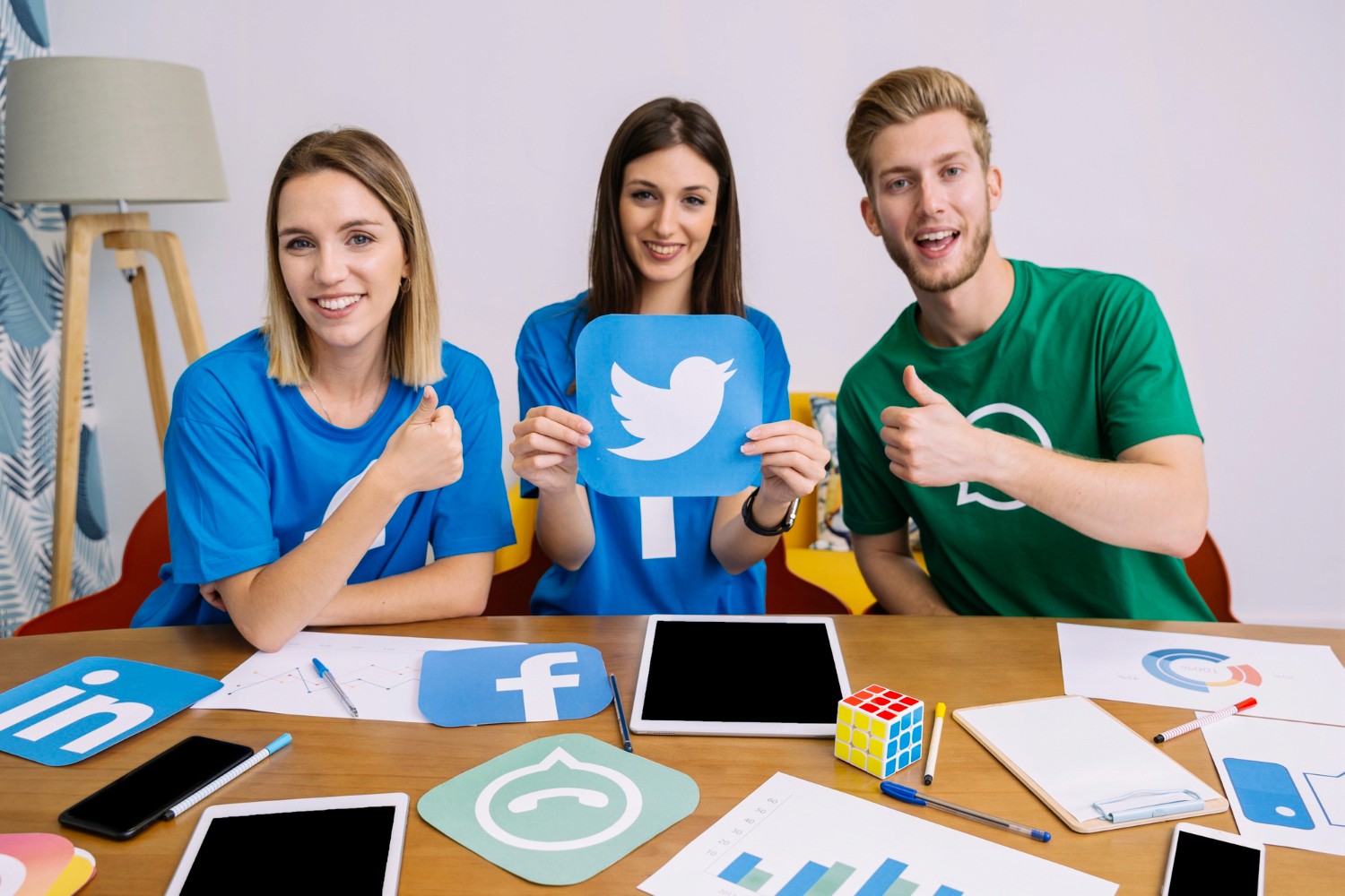 Three individuals engaged in conversation at a table, surrounded by various social media icons.