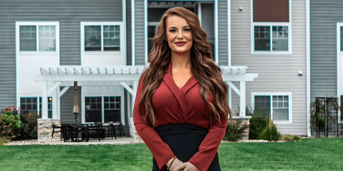 Alexis Anderson, Founder & CEO of Anderson Asset Property Group, stands confidently in front of a modern residential building.