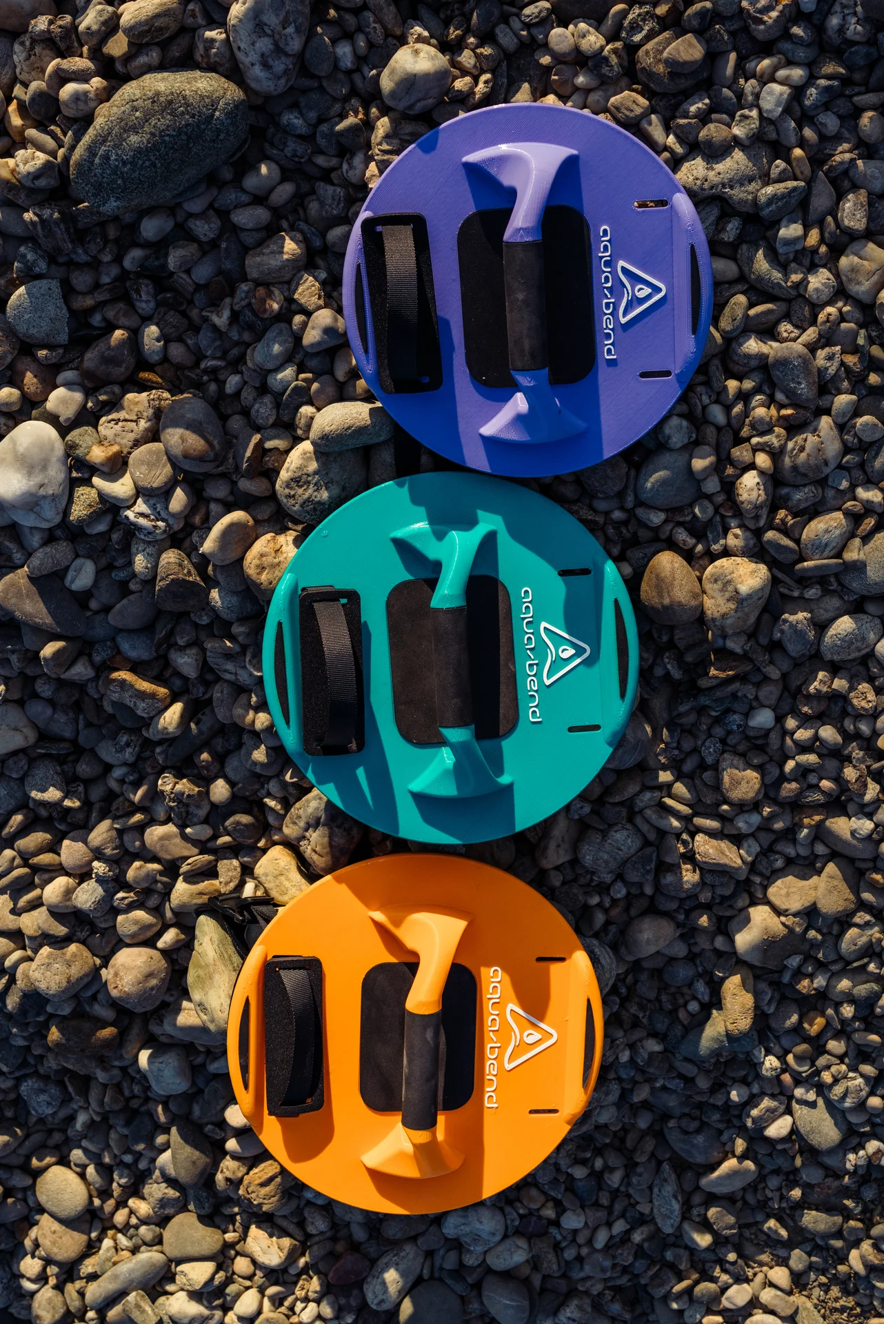 Aqua-Bend FLOW, FIT and FLEX discs in Grip Edition displayed side by side on beach rocks