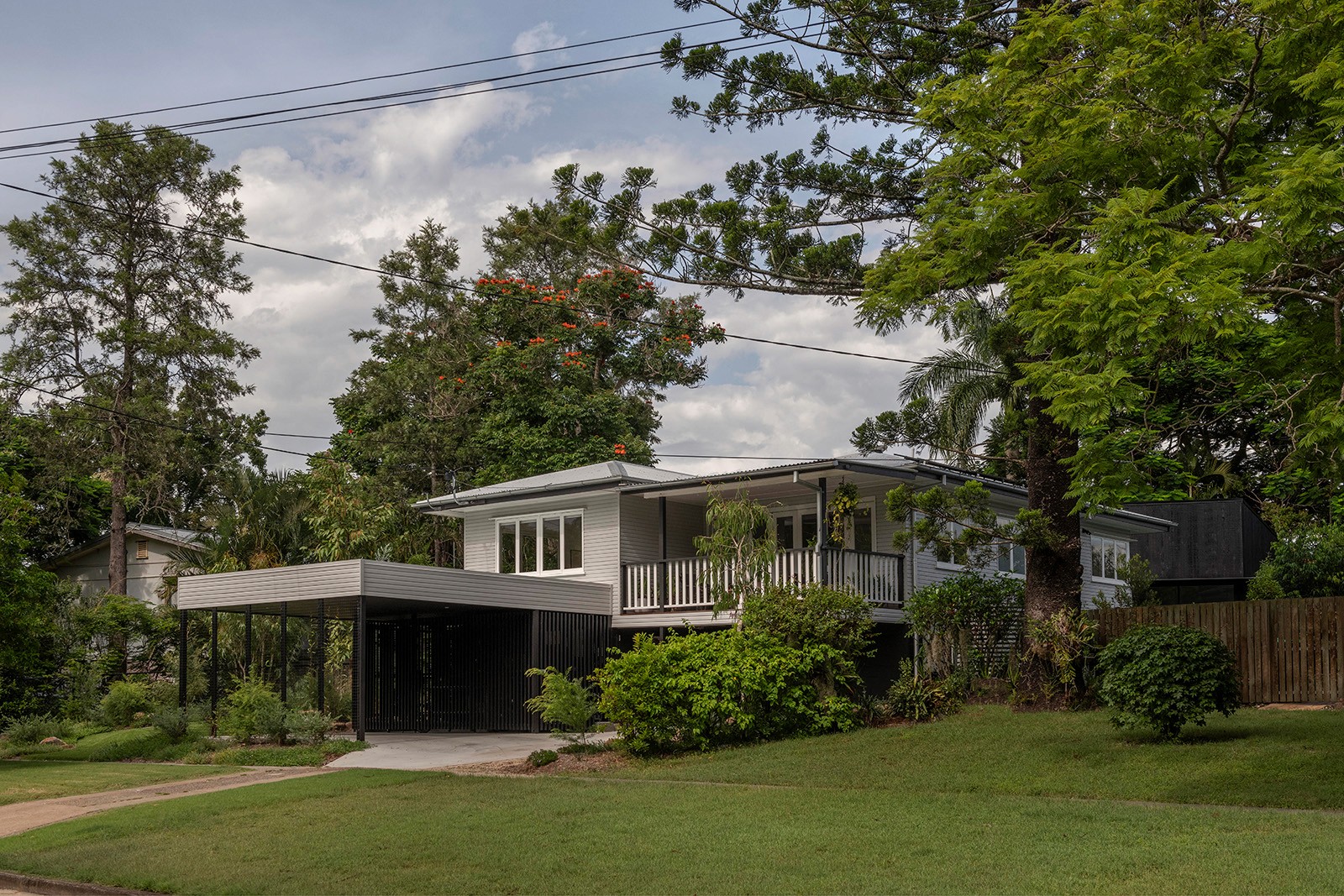 Street view of Toohey Forest House showing retained post-war home, contemporary entry pavilion, and landscaped front garden in Brisbane.