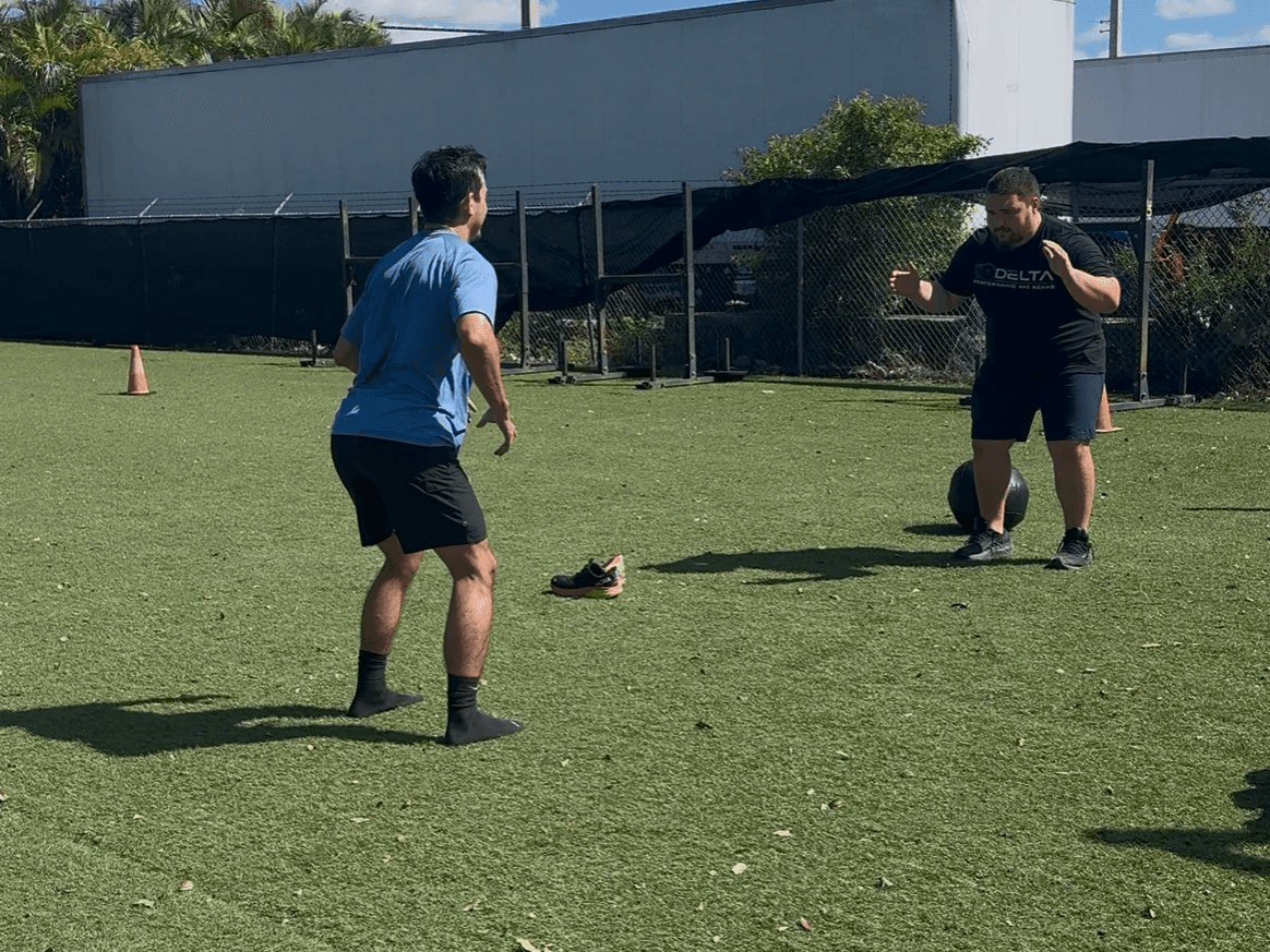 Track and field athlete preparing for a sprint under stadium lights, representing focus, speed, and peak performance—key aspects of athletic rehab and training.
