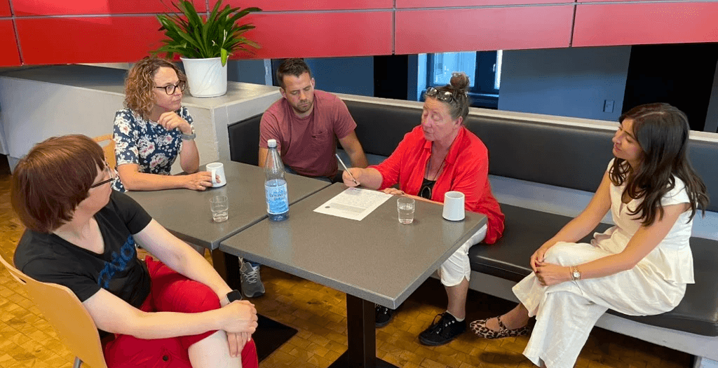 Analoge Beteiligungsformate: Eine generationenübergreifende Gruppe sitzt bei einem Workshop im Stuhlkreis zusammen, um gemeinsam zu diskutieren.