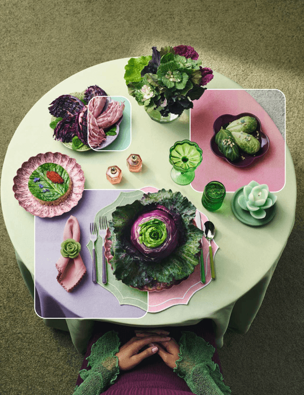 Flat lay image of a green table with an assortment of cooked cabbages and cabbage-themed set pieces.