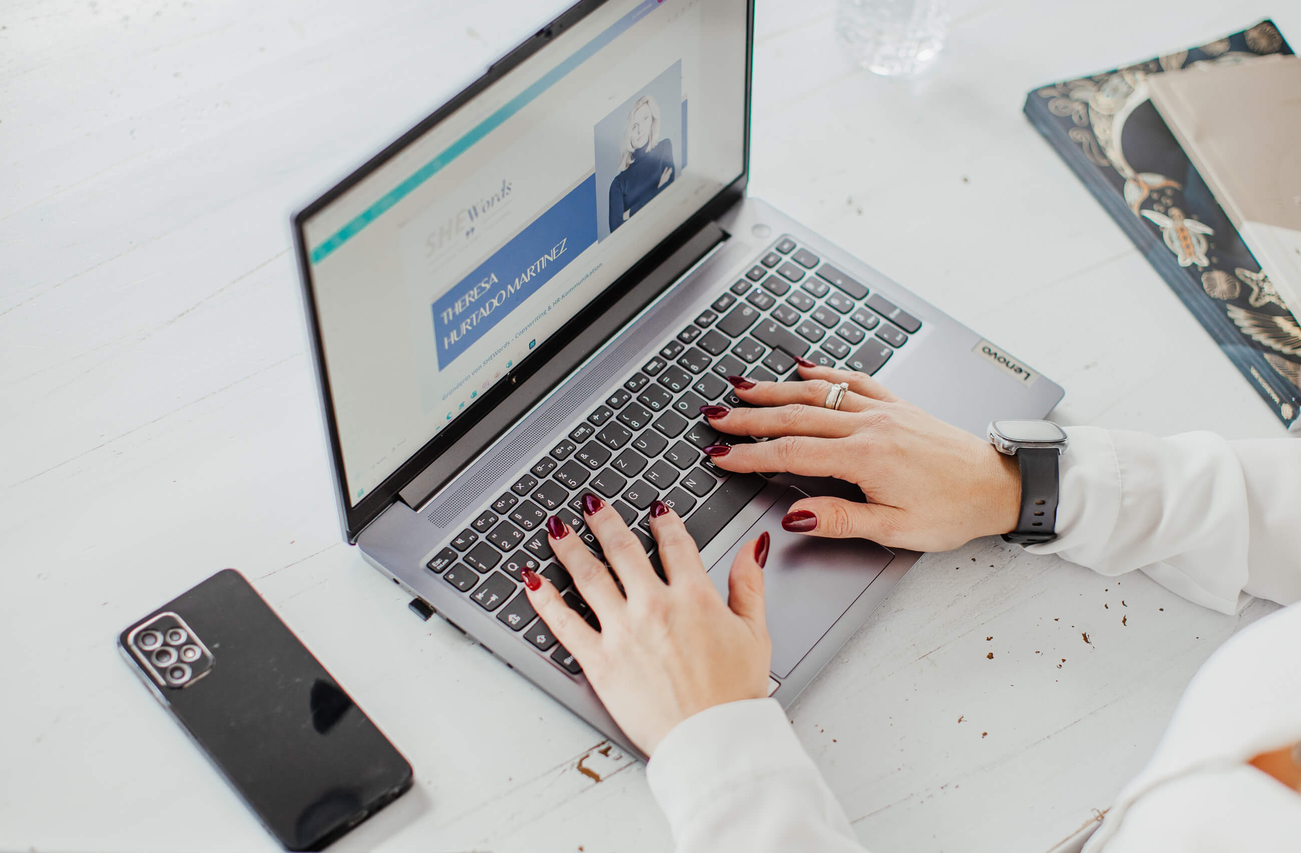 Hände auf Laptop-Tastatur bei der Arbeit, mit "Über SHEWords" Überschrift, symbolisiert HR-Copywriting und strategische Beratung
