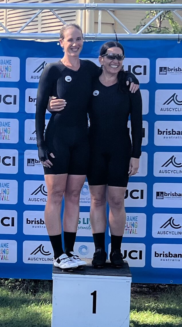 Lily and her pilot, Kelly, standing on the first place podium after winning gold in the time trial in the oceania championships.