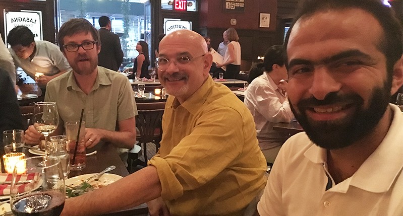 group photo of people sitting at a dinner table