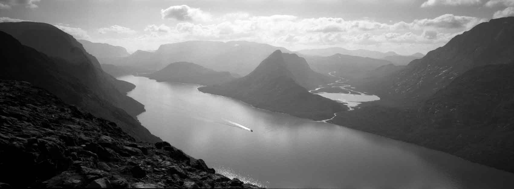 Besseggen in Norway, in black and white photography, with water and mountain ranges in the far distance shot with the Fuji TX 1 with a soft gradient for ND filters photography