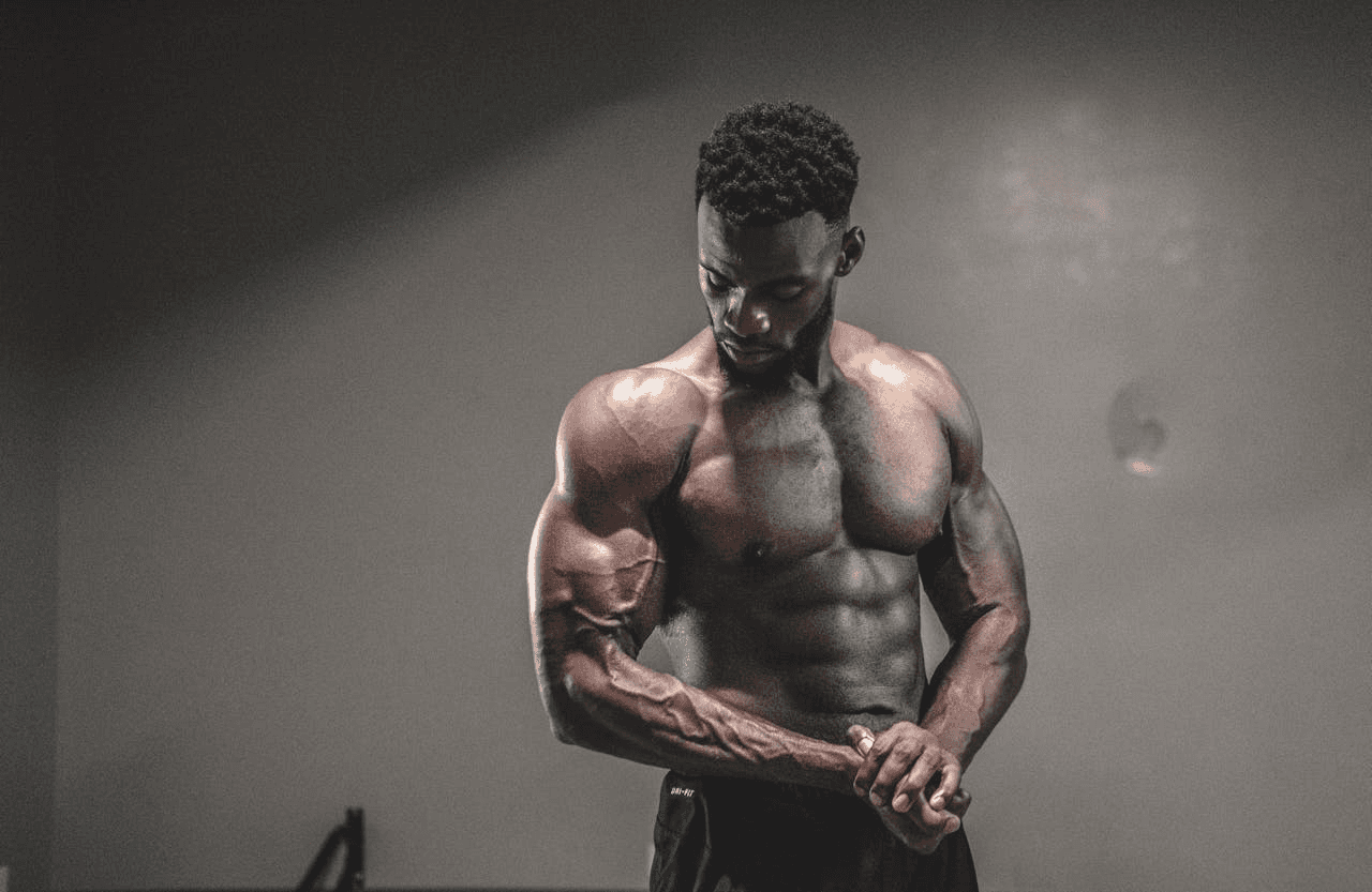A fit young man flexes his ab muscles.