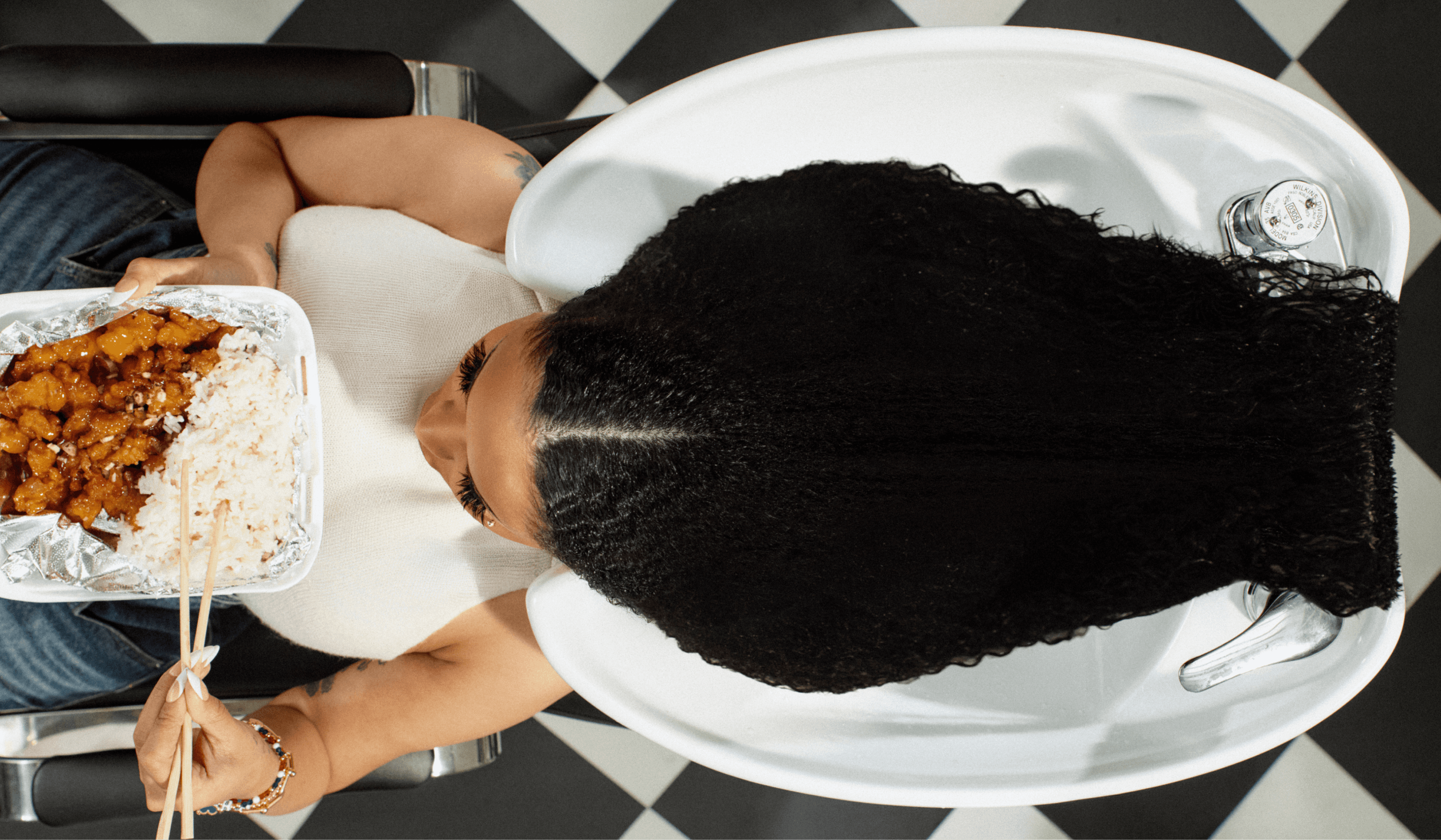 Aerial shot of Cardi B at hair wash at salon bowl — Grow-Good Beauty campaign art direction inspired by Dominican salon culture
